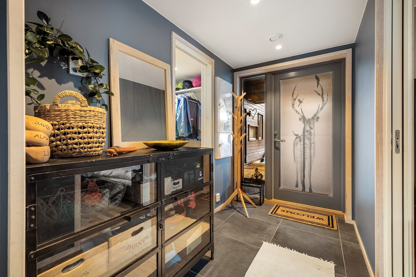 Man kommer inn i en hyggelig entré med flislagt gulv, og god plass til å henge fra seg yttertøyet Galleribilde