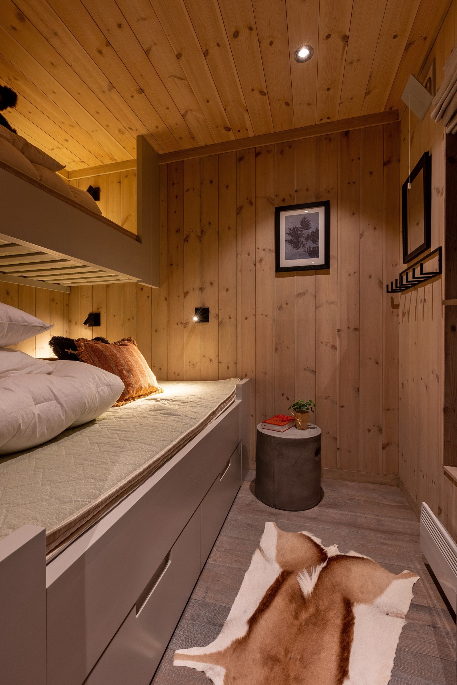 Et av soverommene i annekset har dobbeltseng med skuffer under og køyeseng over. Galleribilde