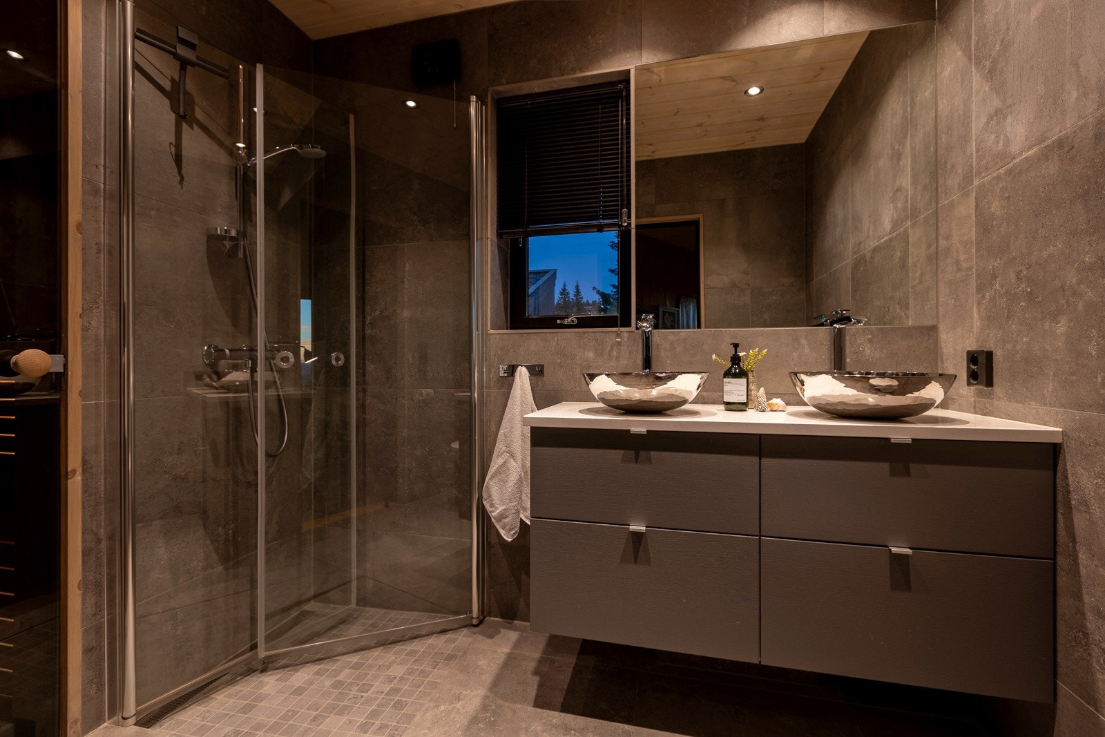 Dusjhjørne med innfellbare dører sørger for at plassen blir optimalt utnyttet i gjestebadet i hovedhytta. Galleribilde