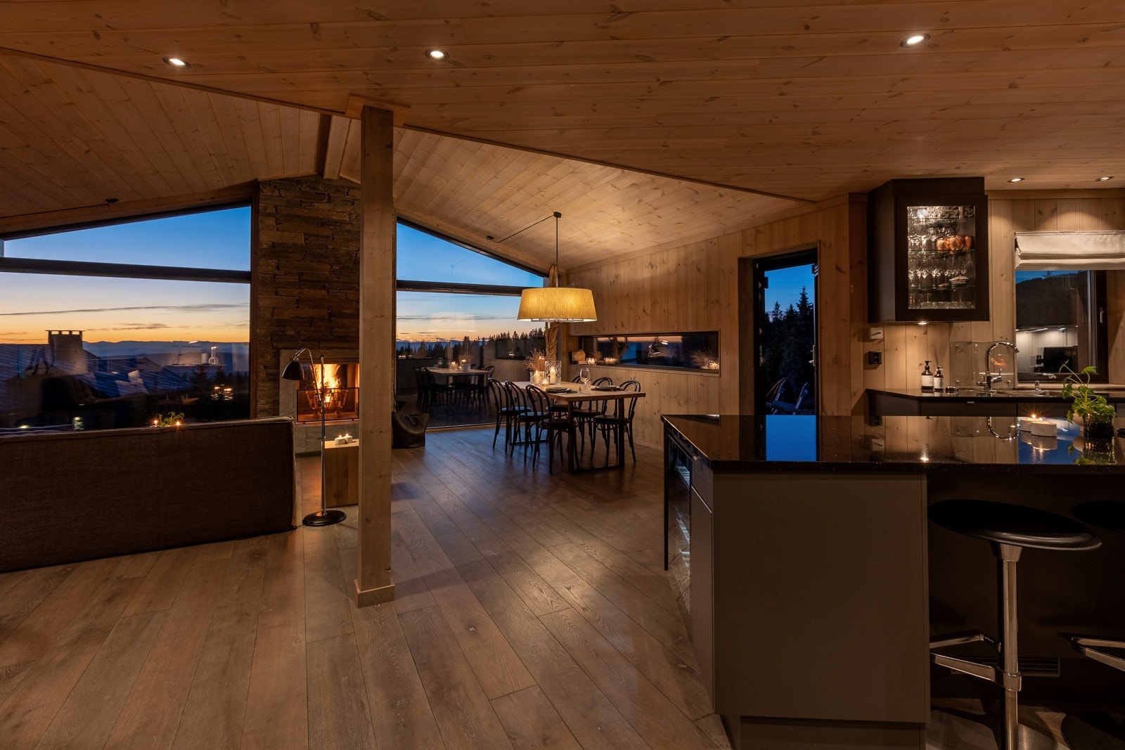 Åpent og spennende oppholdsrom med vinduer fra gulv til tak som gir kontakt med skog, lys og storslagen utsikt Galleribilde