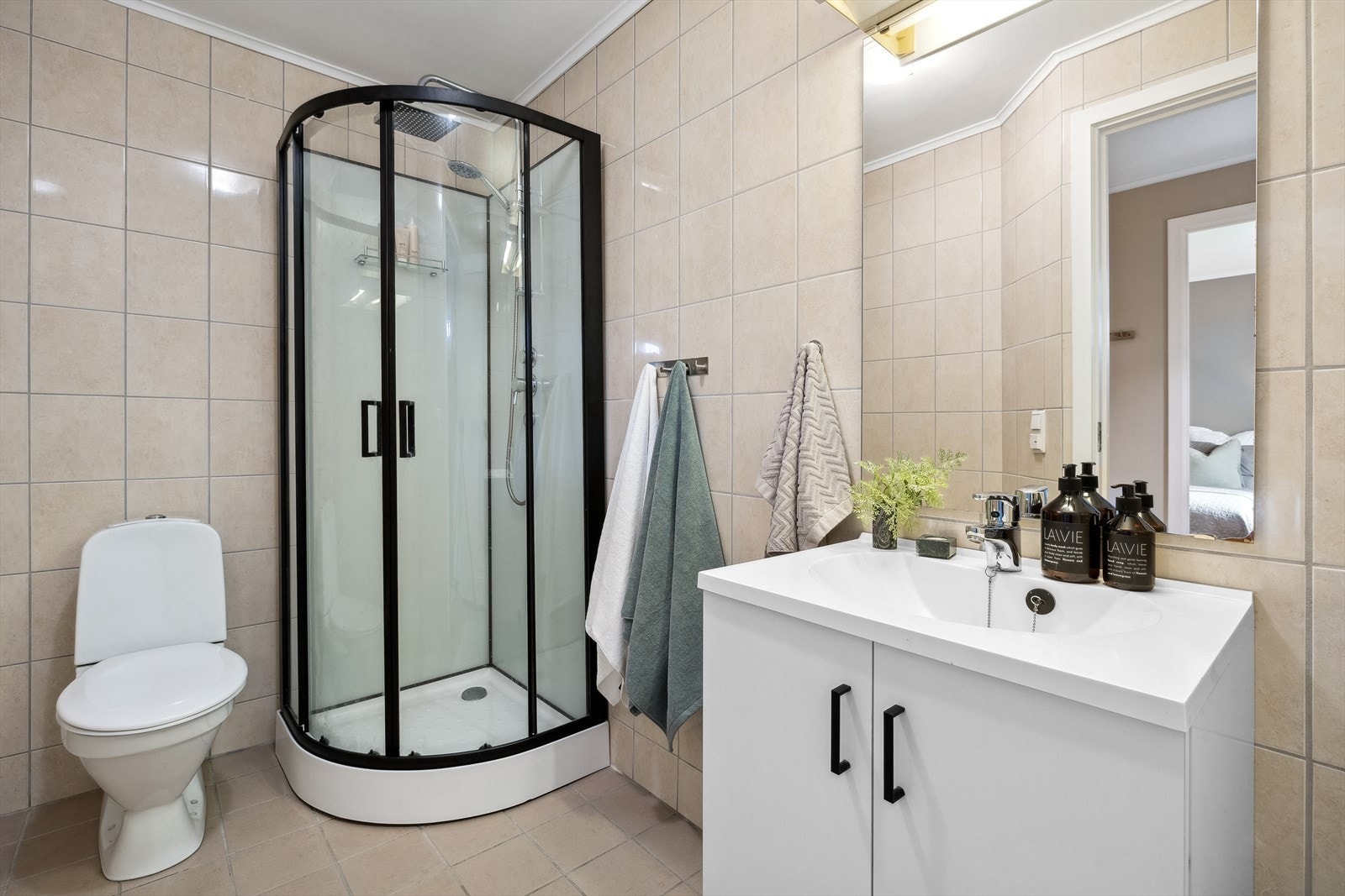 Leiligheten har et pent og helfliset baderom med behagelig gulvvarme. Rommet har baderomsinnredning med heldekkende servant og underskap med dører, frittstående toalett og dusjkabinett. Tappekran og avløp for vaskemaskin. Galleribilde