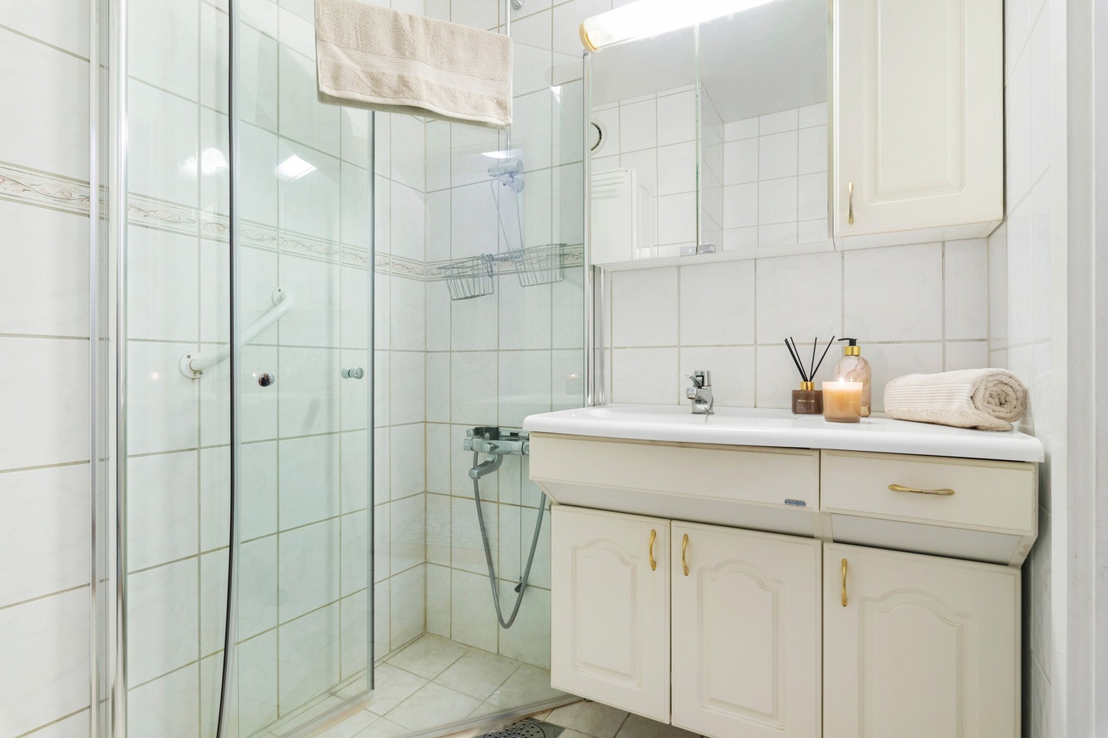 Badet har dusjnisje med foldedører Galleribilde