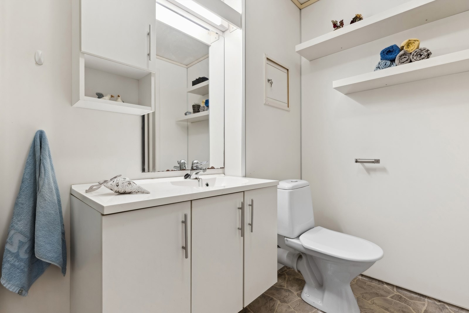 Badet har belegg på gulvflaten med oppkant på vegg, våtromsplater på vegger og malte plater i himling. Avtrekk fra rommet via mekanisk avtrekksvifte i vegg. Tilluft via luftespalte under dør til gang Galleribilde