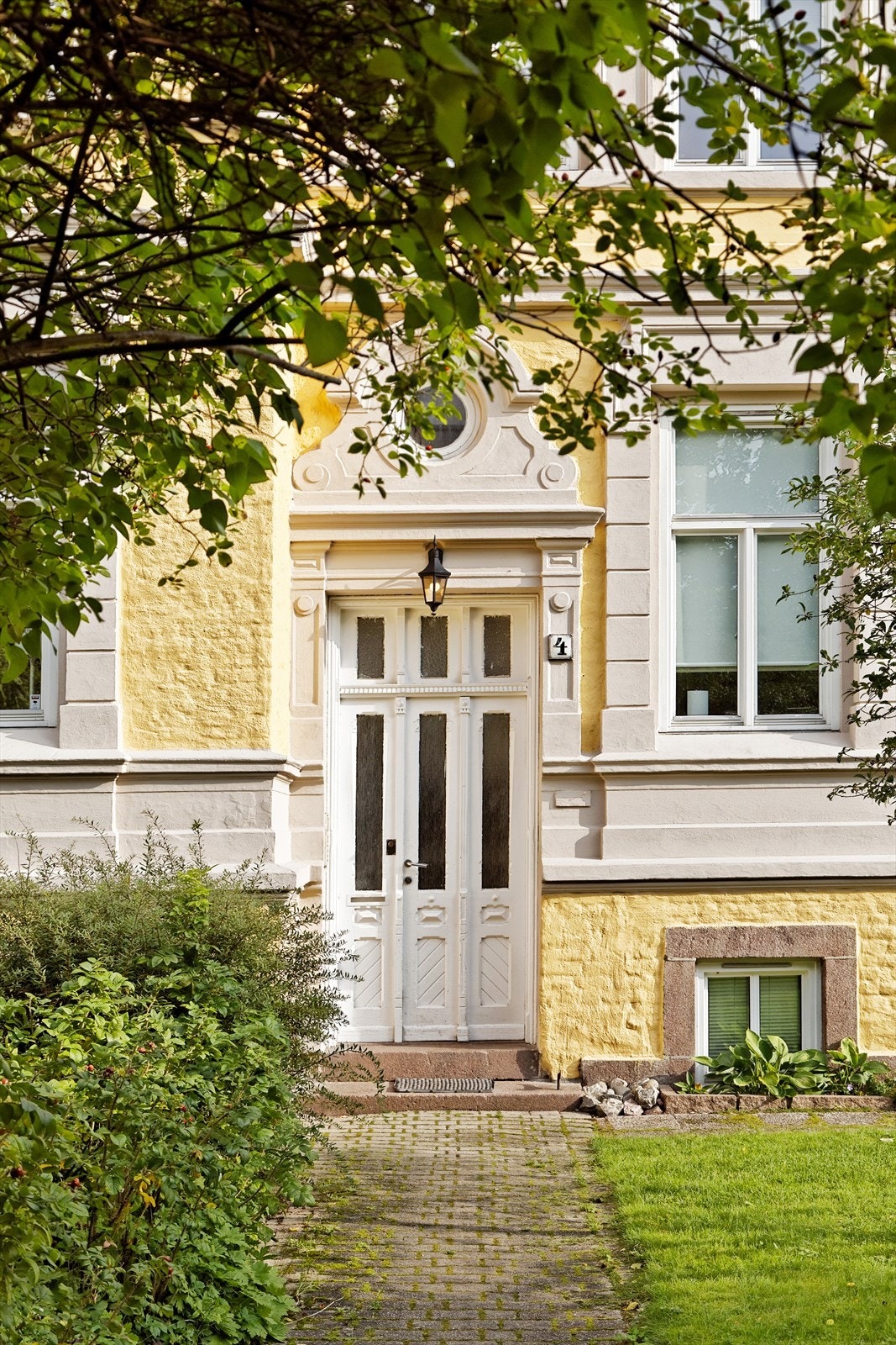 Pent opparbeidet tomt med gressplen, beplantning og brostein - Representativt inngangsparti Galleribilde