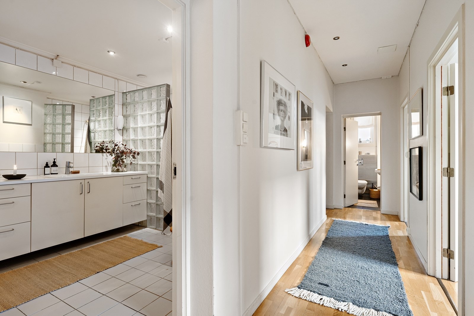 Stort flislagt baderom med varmekabler i gulv og downlights i himling Galleribilde