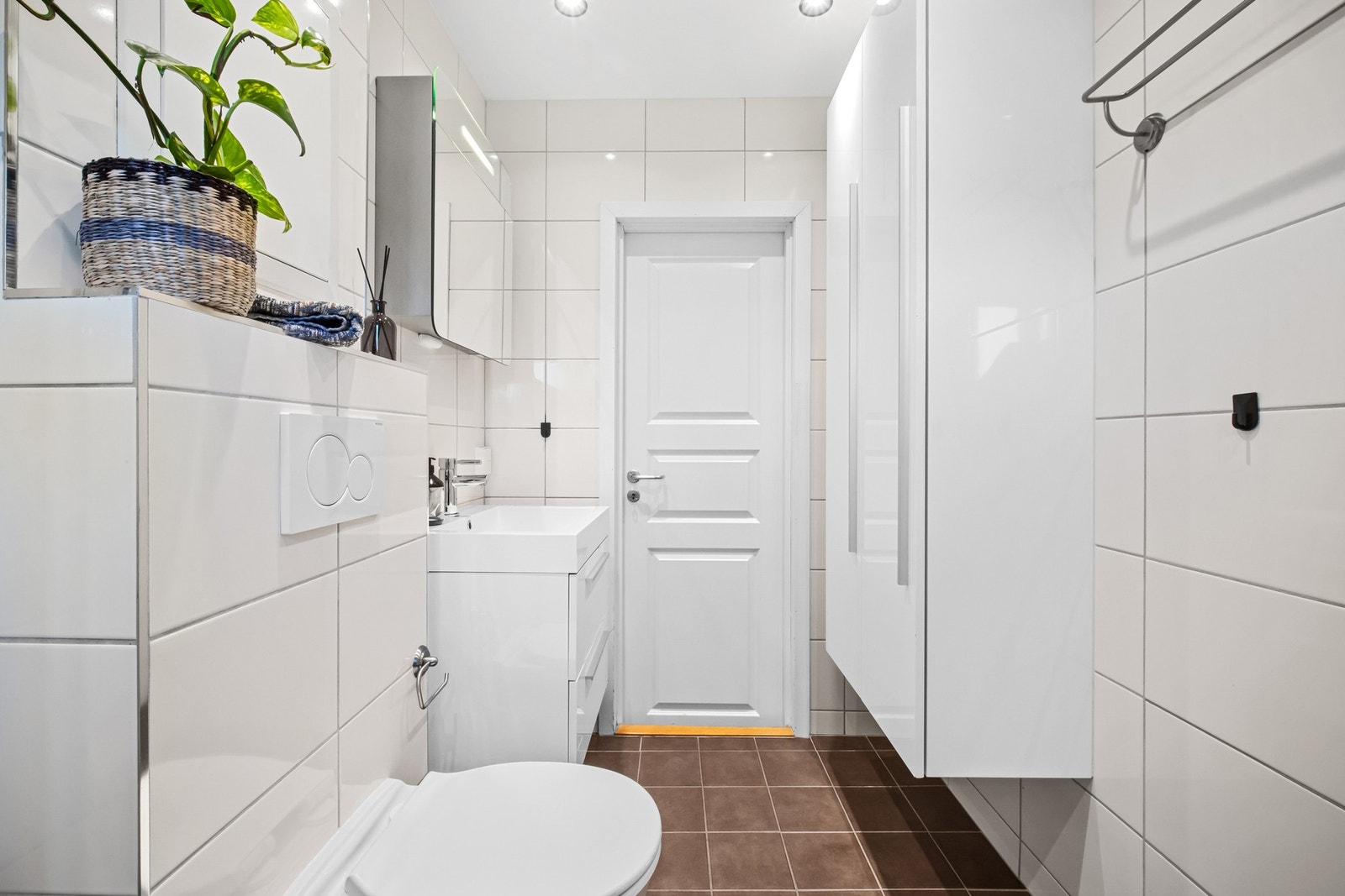 Av innredning har rommet dusjhjørne, vegghengt toalett, et hvitt, høyglanset baderomsmøblement og opplegg for vaskemaskin. Vaskemaskin medfølger. Galleribilde