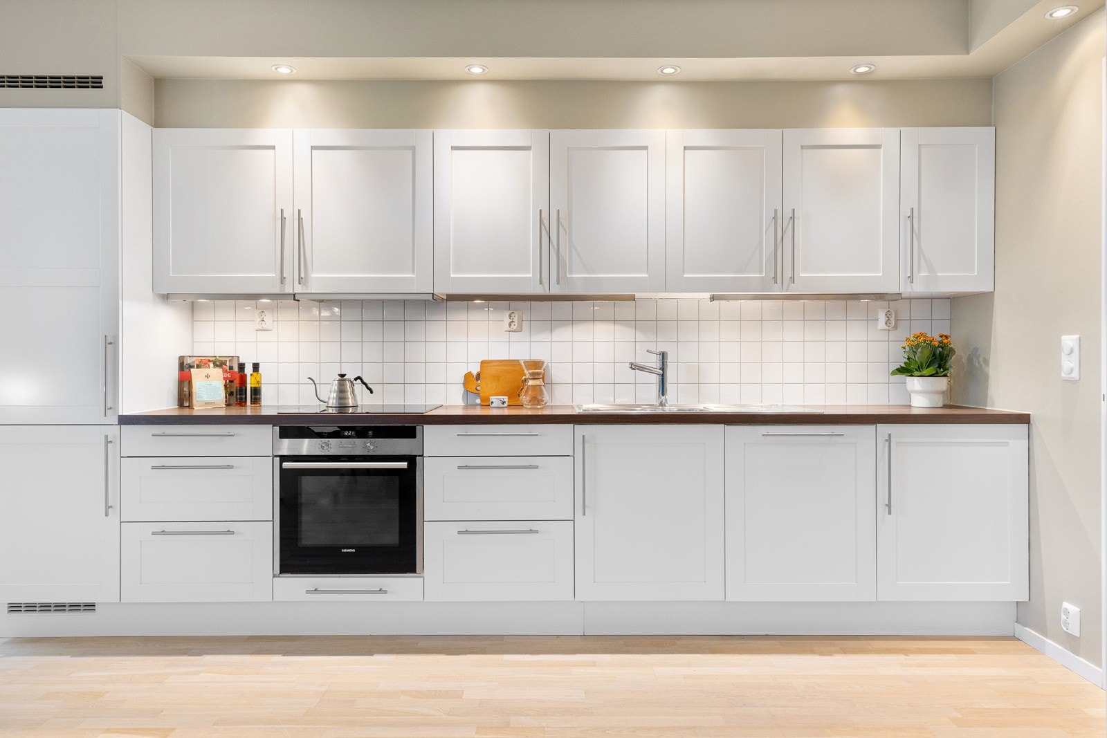 Innredningen fra Sigdal har profilerte fronter og benkeplate i laminat med nedfelt oppvaskkum. Alle hvitevarene er integrerte i innredningen. Galleribilde