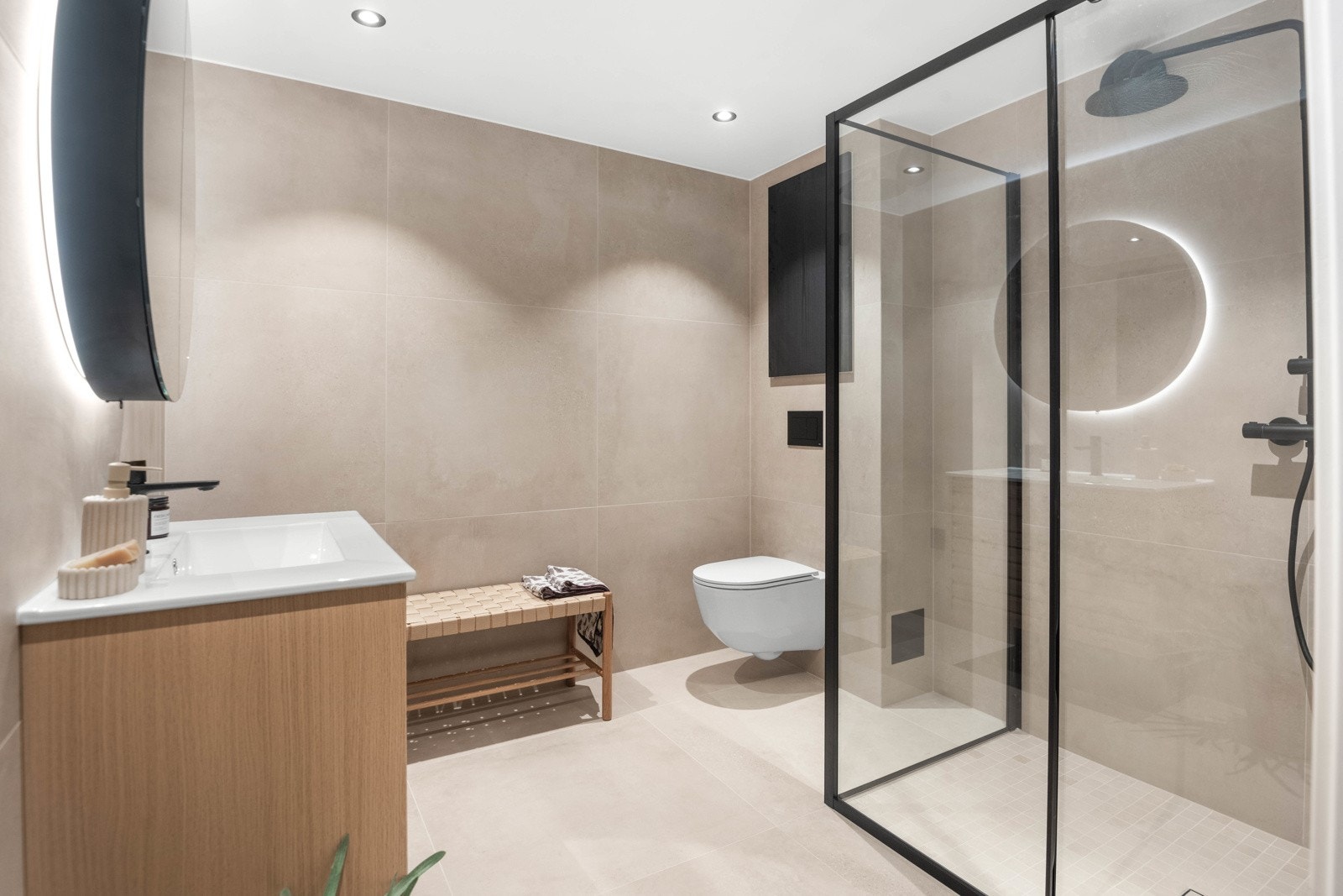Badet ble revovert i 2024 som resten av boligen. Baderommet oppleves som stilrent og moderne med store lekre fliser, stilige detaljer i sort, varmekabler i gulv og downlights i himling Galleribilde