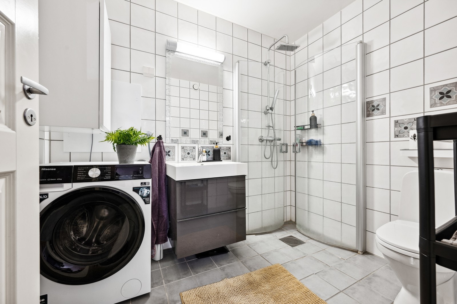 Baderom med wc, dusjhjørne og vaskemaskin. Galleribilde
