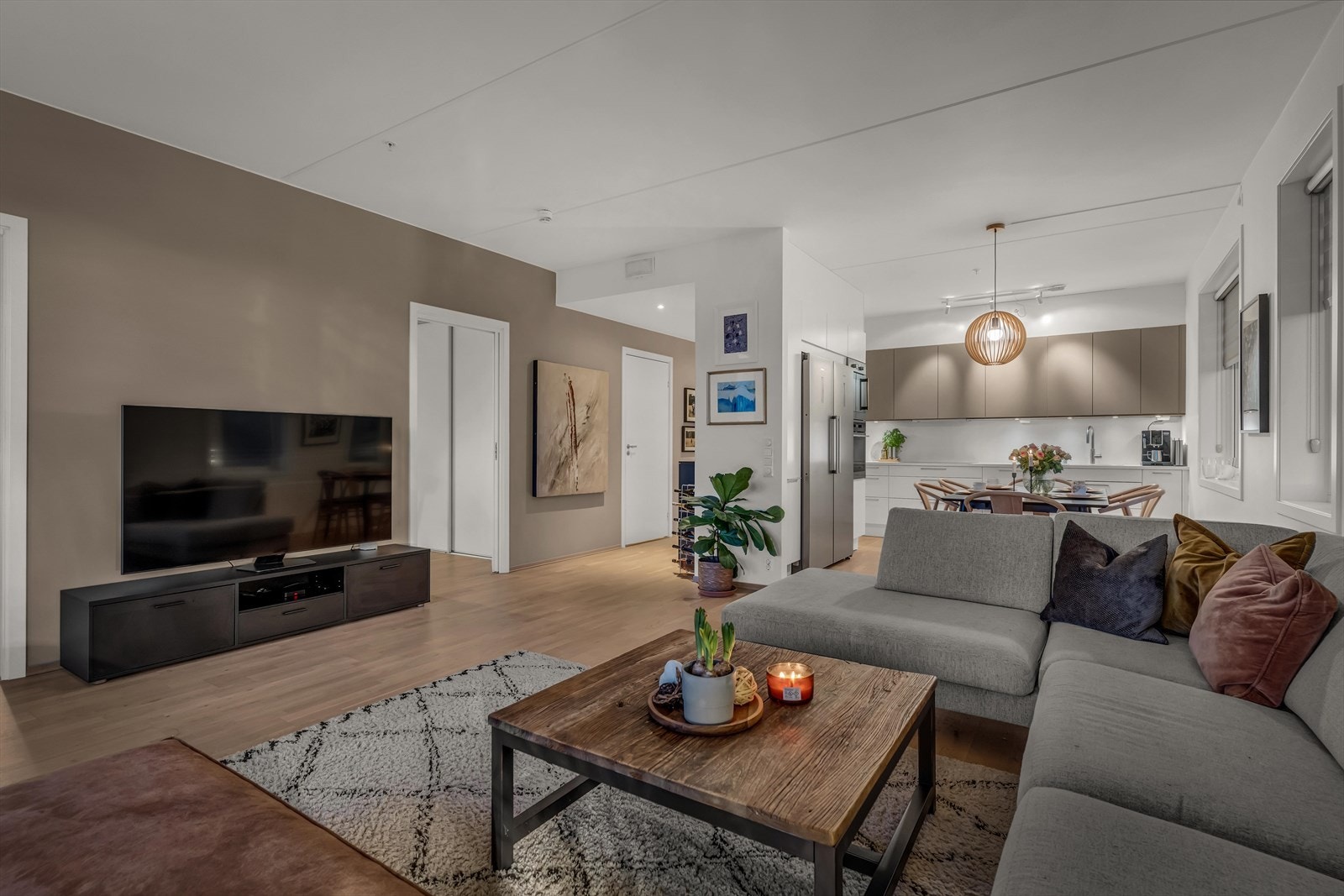 En lys og innbydende stue med store vinduer som fanger sollyset fra to himmelretninger. Her er det perfekt plass til både sofahjørnet og middagsbordet. Galleribilde