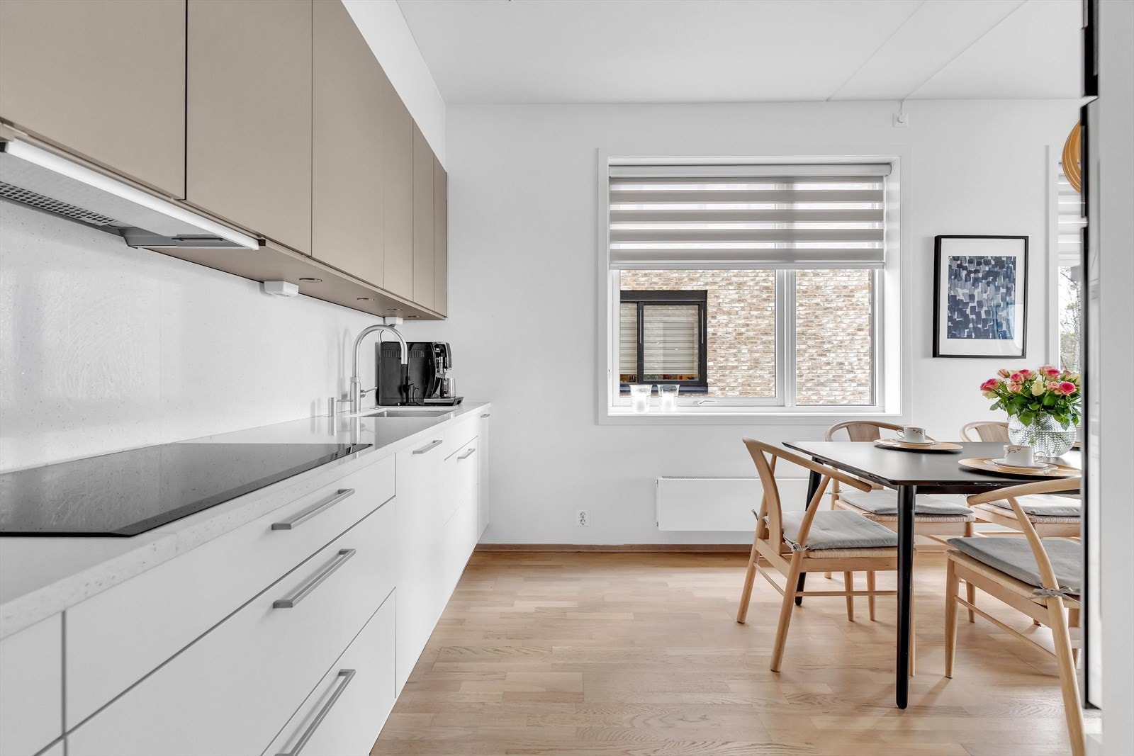 På den andre veggen er det matlagingssone med platetopp og god benkeplass, samt installert Quooker integrert oppvaskmaskin. Galleribilde