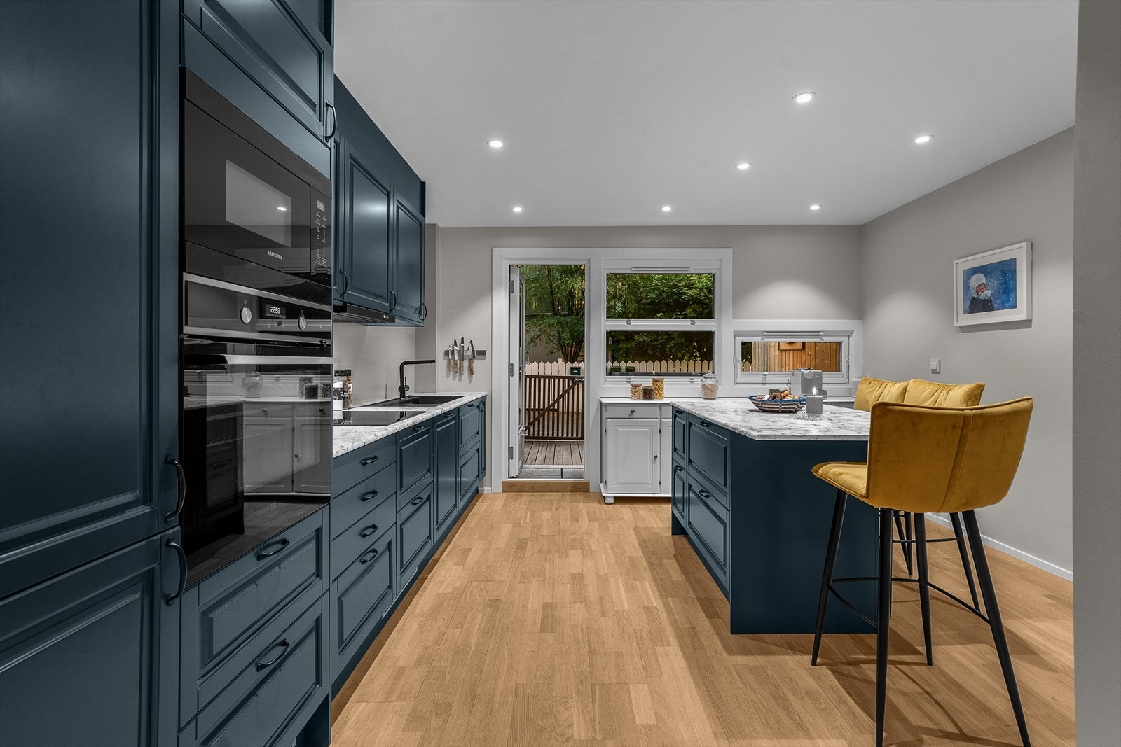 Stilrent moderne kjøkken med romslig arbeidsbenk og integrerte hvitevarer. Galleribilde