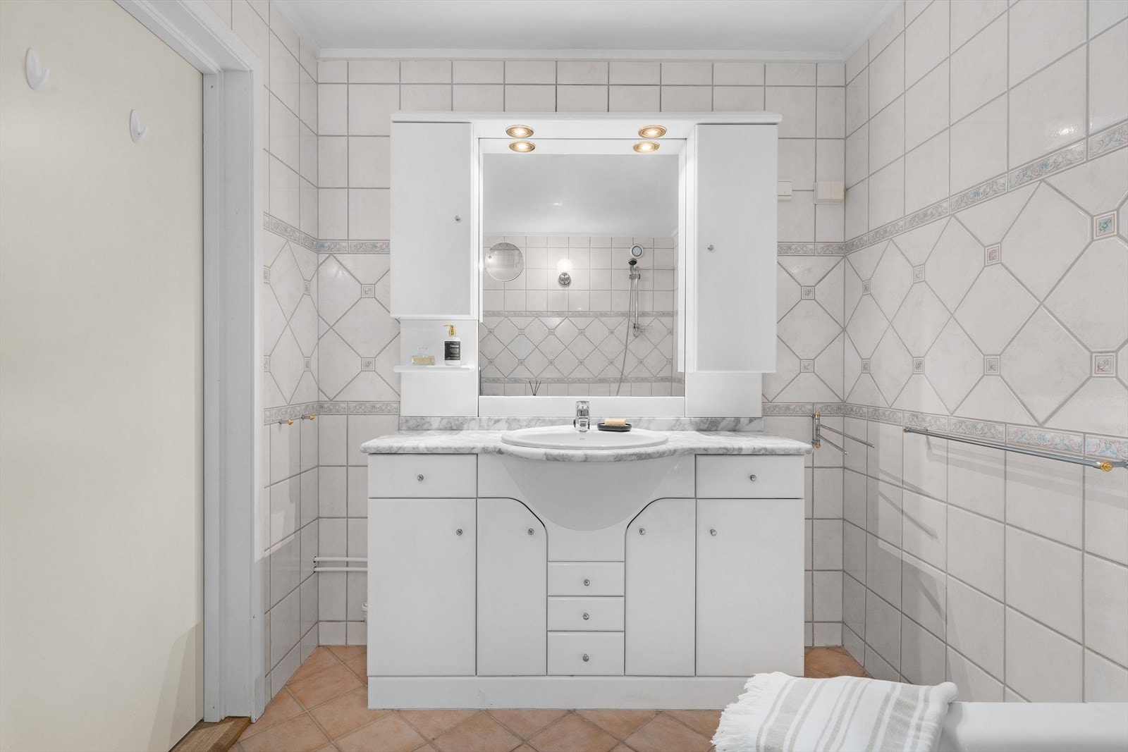 Innredning består av baderomsmøbel med nedfelt servant, underskap/skuffer og 1-greps blandebatteri, badekar og gulvstående toalett. Galleribilde