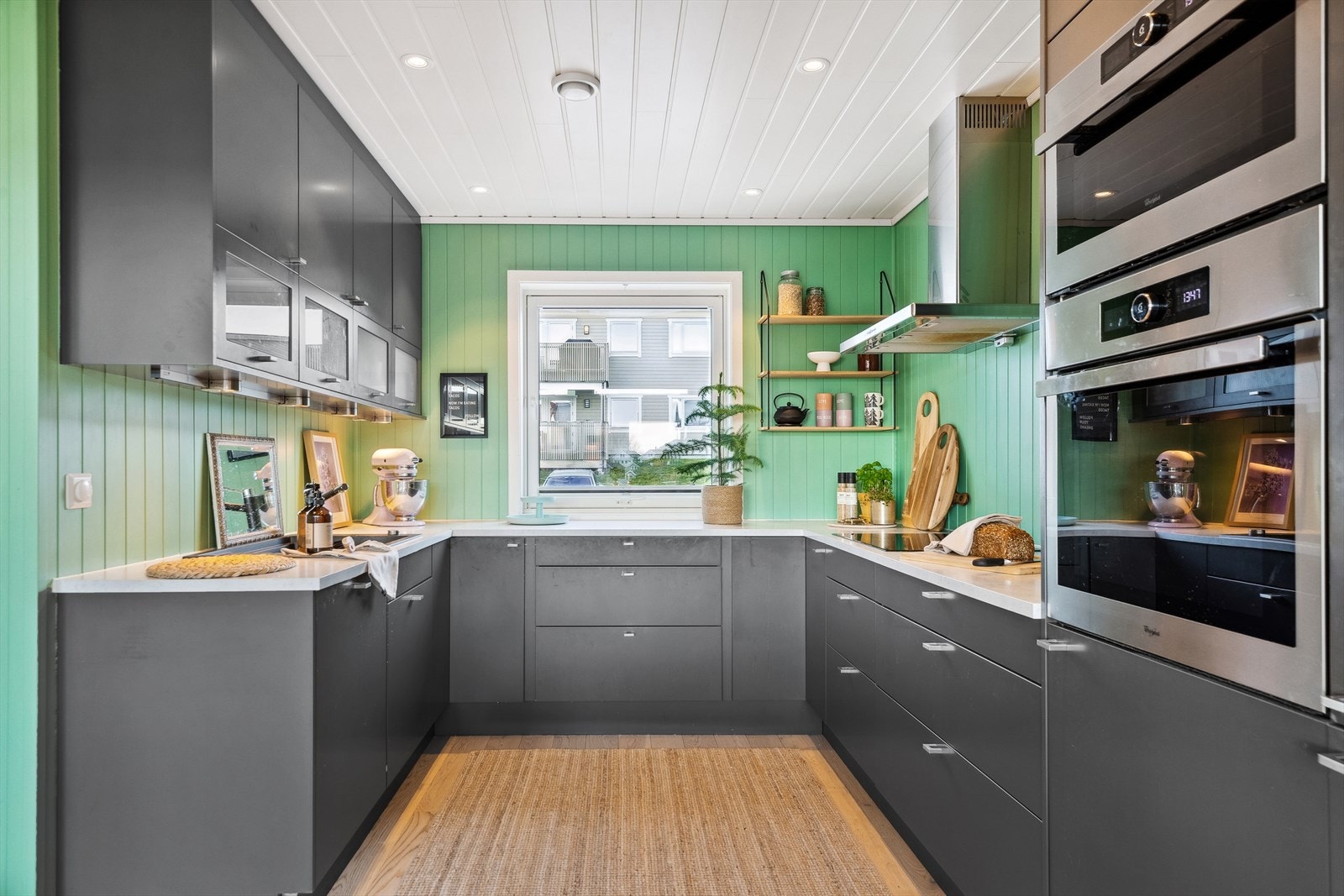 Enkelte av overskapene har glass, og en stor komposittkum er nedfelt i den lyse benkeplaten. Galleribilde