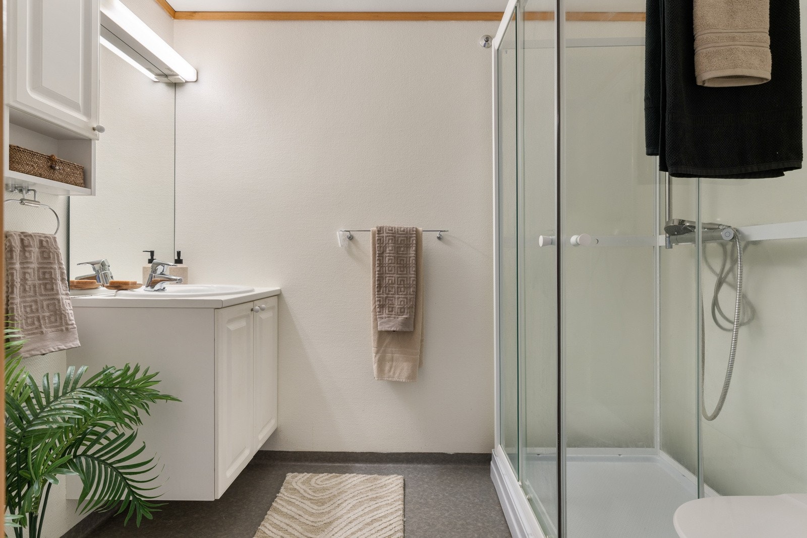 Baderommet er av praktisk karakter, og er videre utstyrt med dusjkabinett, servant med underskap, toalett og opplegg for vaskemaskin. Galleribilde