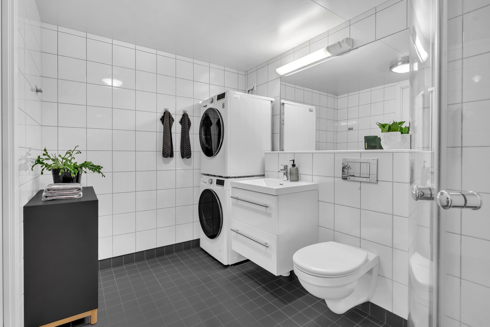 Servant med ett-greps blandebatteri. Veggmontert toalett med innebygget sisterne. Galleribilde