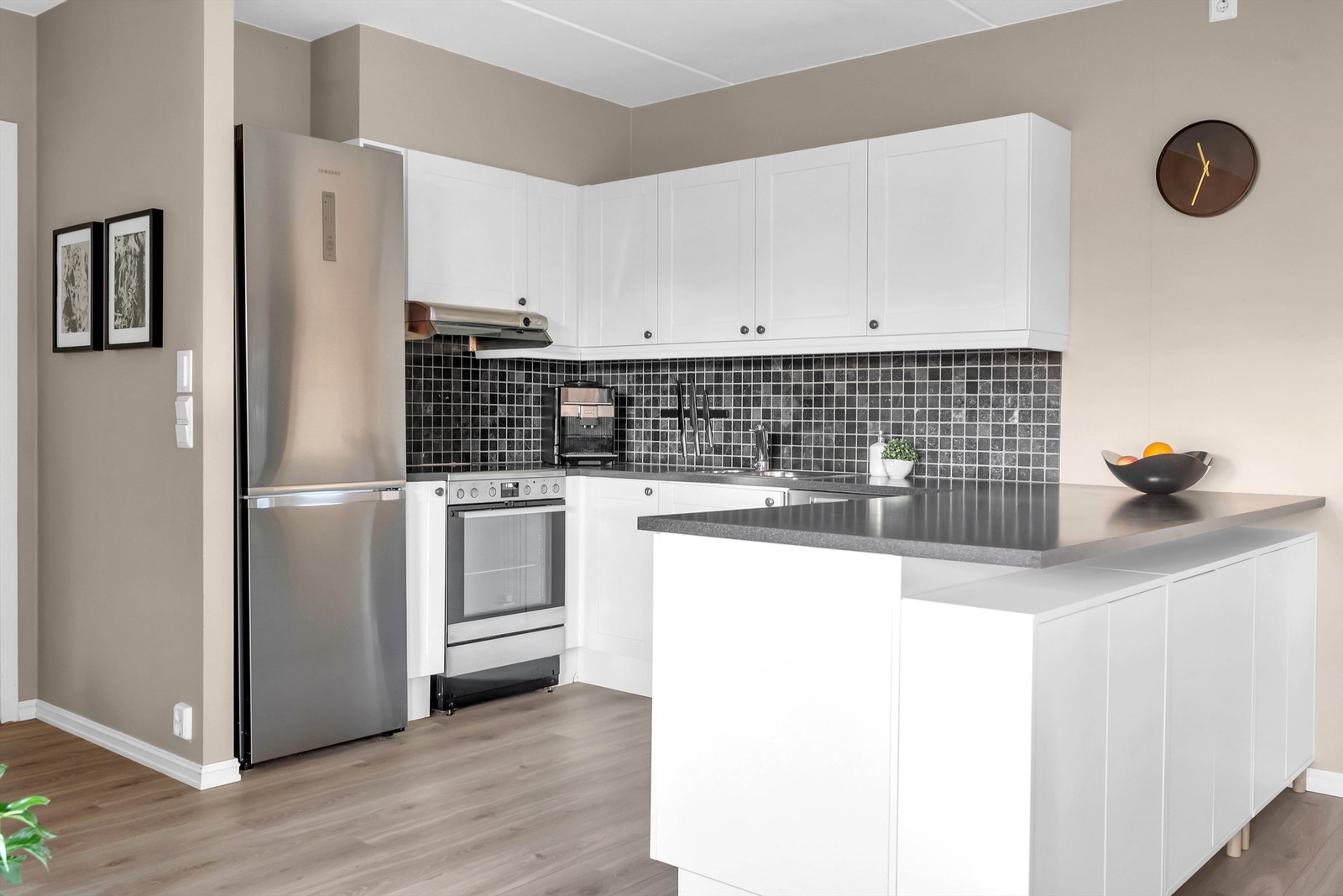 Kjøkkeninnredning i åpen løsning fra 2015 med lyse ett-speils fronter. Galleribilde