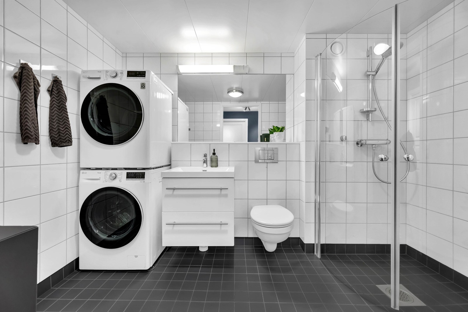 Baderomskabin fra 2009 med flislagte vegger og takplater i himling. Det er etablert et mekanisk avtrekk på badet og en tilstrekkelig luftespalte under dørbladet til baderomsdøren. Dusj med dusjdører og hånddusj. Galleribilde