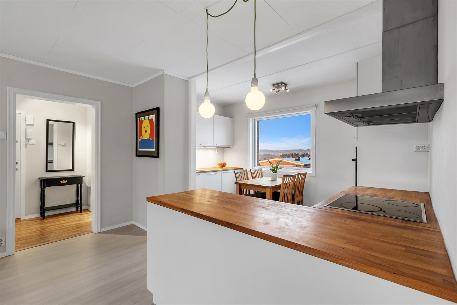 Romslig og praktisk HTH kjøkken fra 2010 med laminat på gulv, tapet på vegger og malt tak. Galleribilde