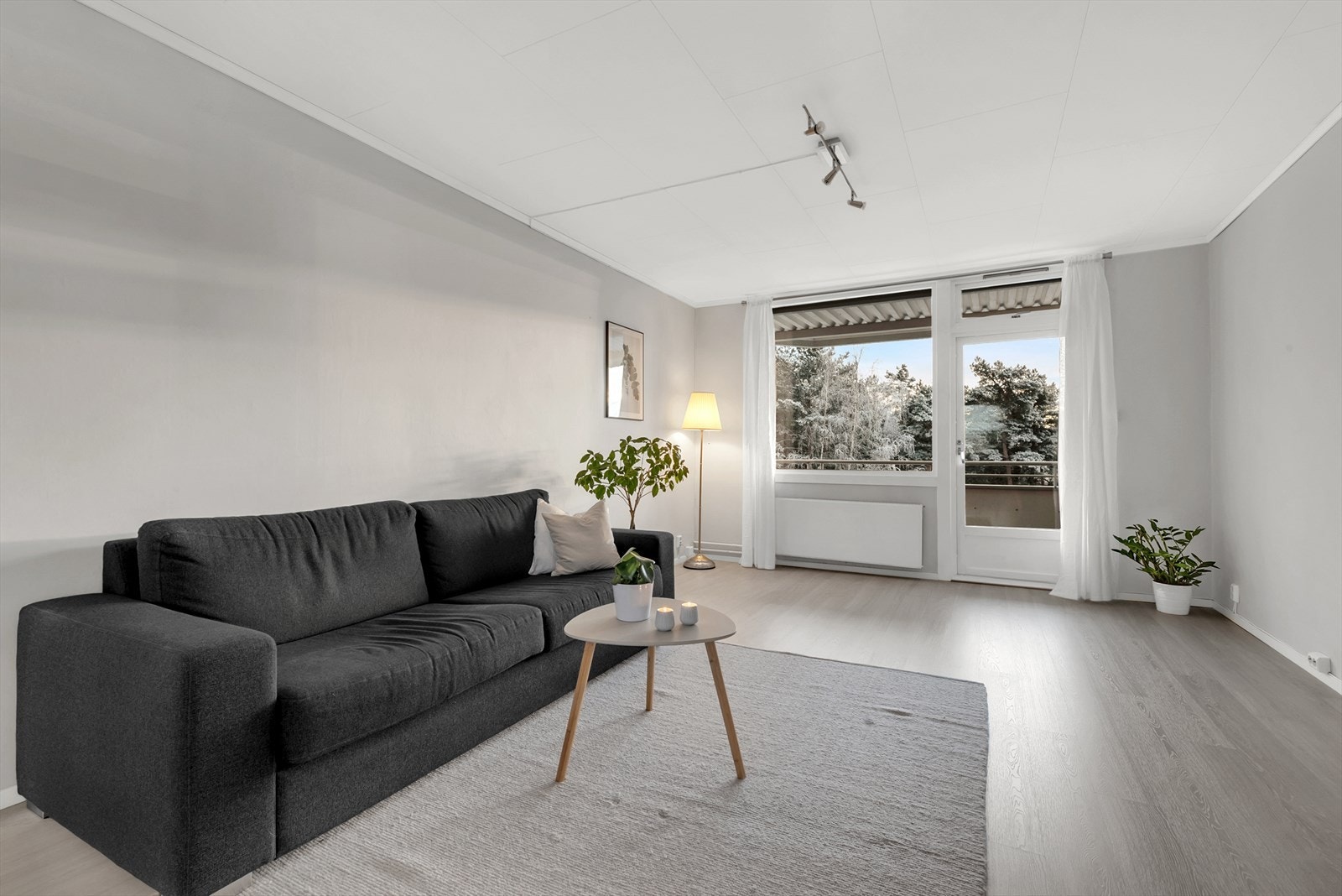 Lys og romslig stue med laminat på gulv, tapet på vegger og takessplater i tak. Her er det god plass for både sofagruppe samt spisemøblement. Galleribilde