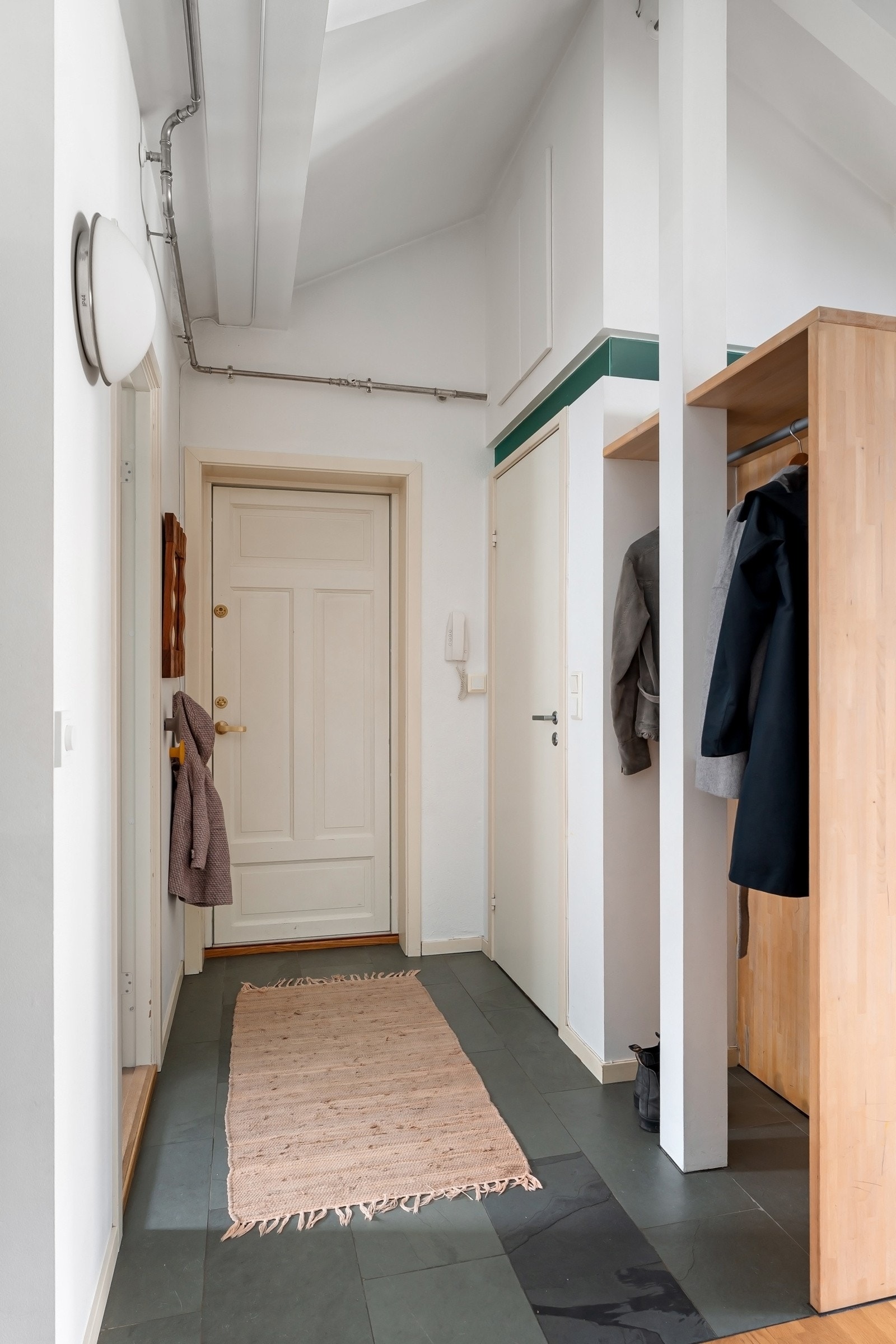 Stor og lys entré med flislagt gulv med varme og smart garderobeløsning. Praktisk bod over badet. Galleribilde