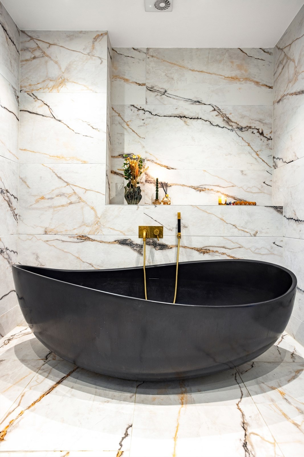 Det sorte badekaret står i kontrast til de lekre marmorflisene. Med dempet belysning kommer spa-følelsen frem! Galleribilde