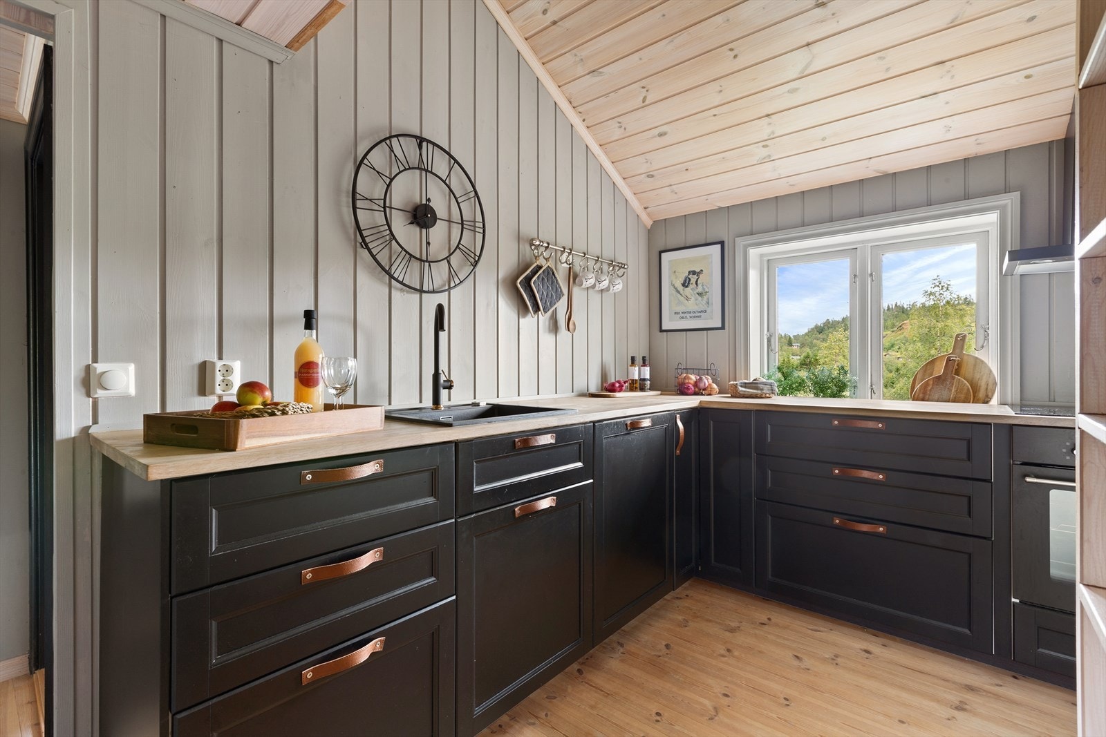 Med mørke, profilerte fronter og en heltre benkeplate, er dette et rom som inviterer til matlaging Galleribilde