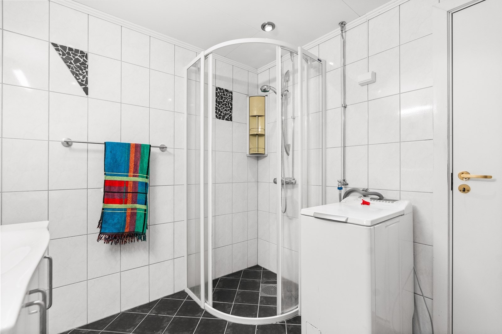 Det er baderomsmøbel, toalett, dusjhjørne og opplegg for vaskemaskin. Galleribilde