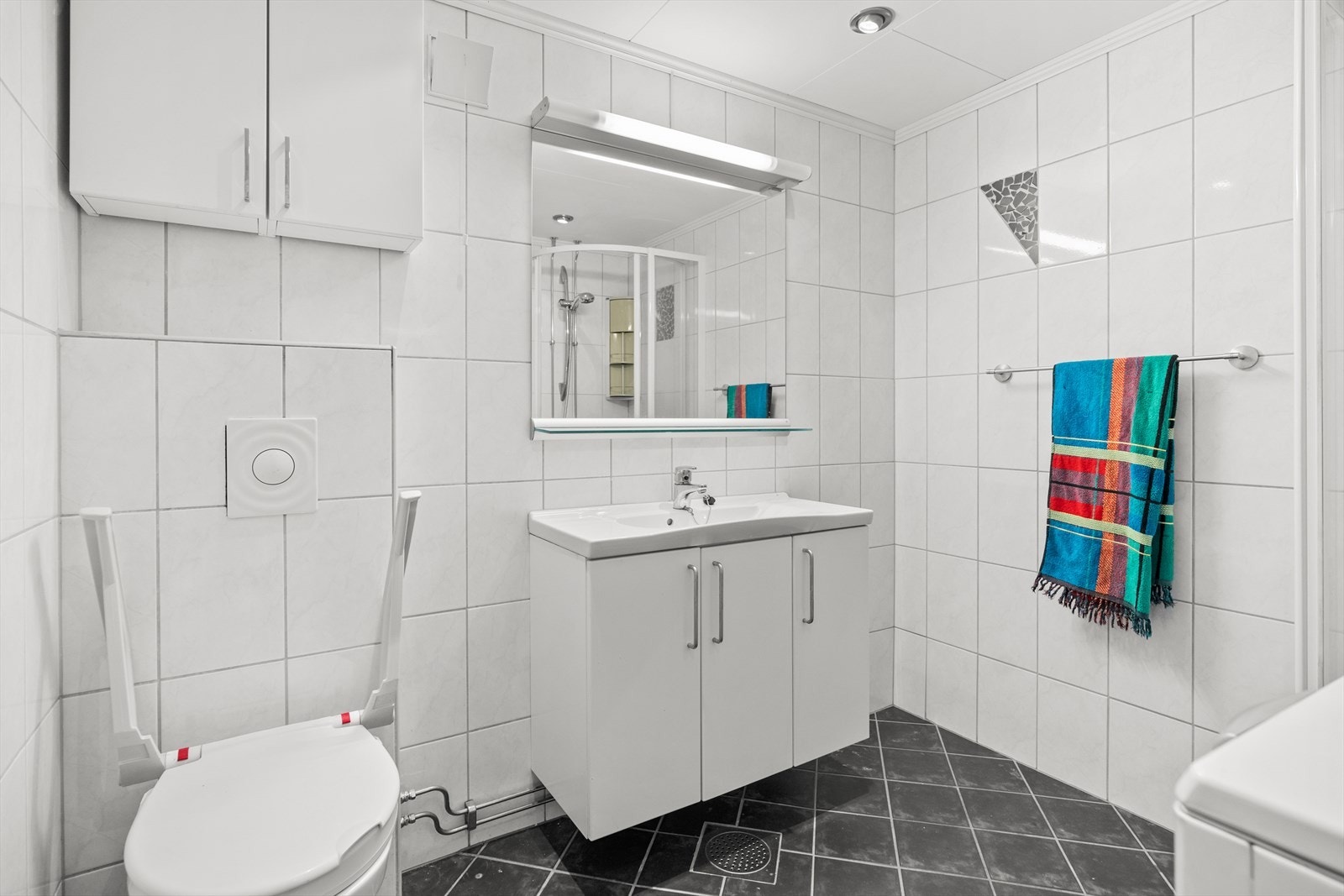 Badet ble pusset opp i borettslagets regi i 2011. Det er fliser på vegger og gulv. Galleribilde