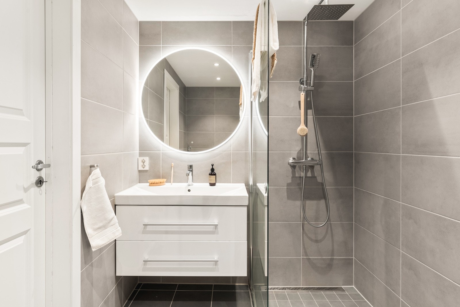 Badet er utstyrt med veggmontert toalett, moderne dusjløsning med hjørnevegg, nedfelt servant. Galleribilde