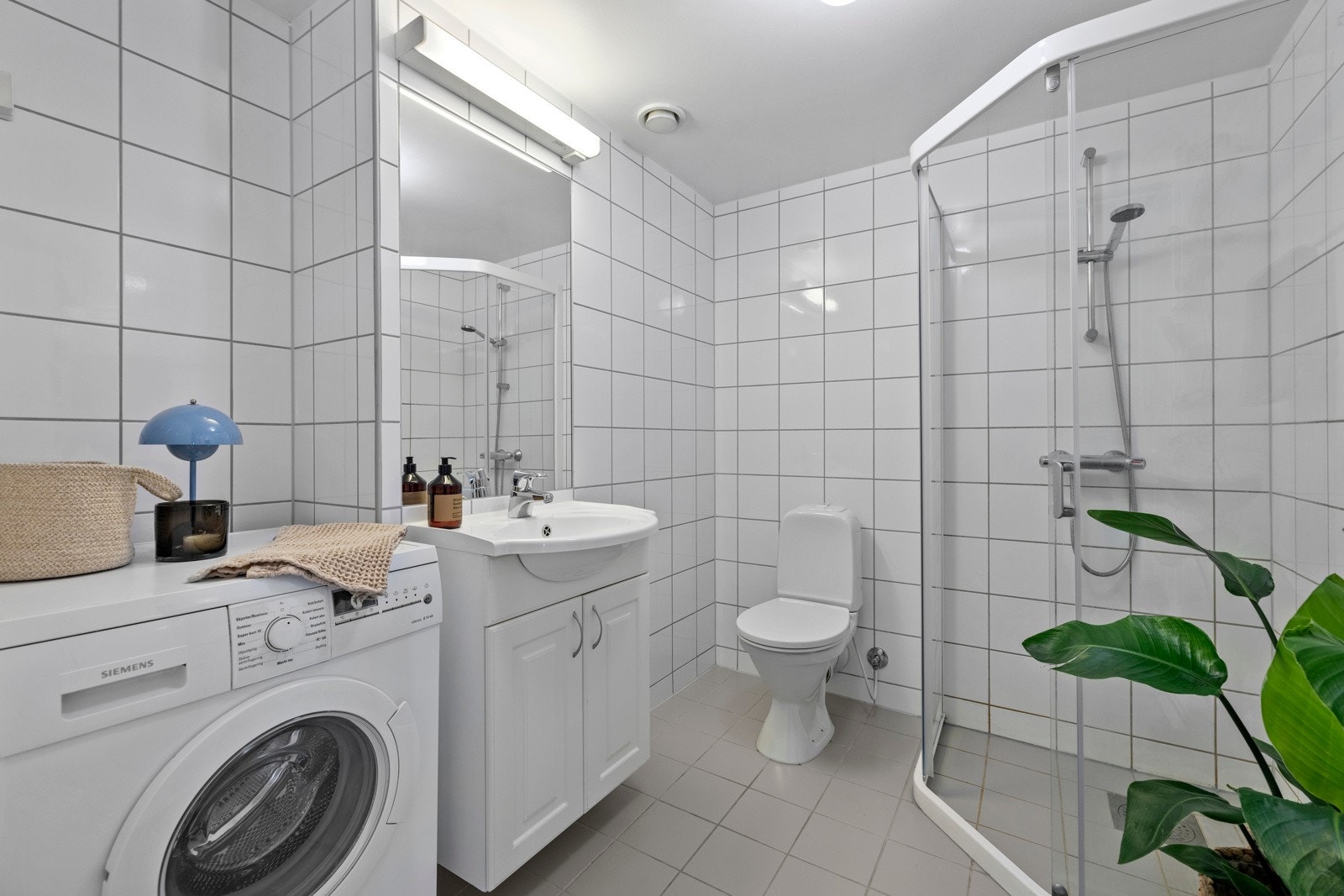 Boligen har et lyst helfliset bad med elektriske varmekabler. Galleribilde