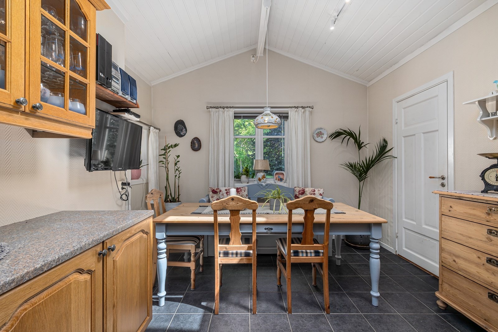 Kjøkkenet har innredning med profilerte fronter. Benkeplaten er av laminat med nedfelt oppvaskkum. Integrert steketopp, komfyr, fryseskap og oppvaskmaskin. Flis på gulv. Stor takhøyde i del av rommet. Galleribilde