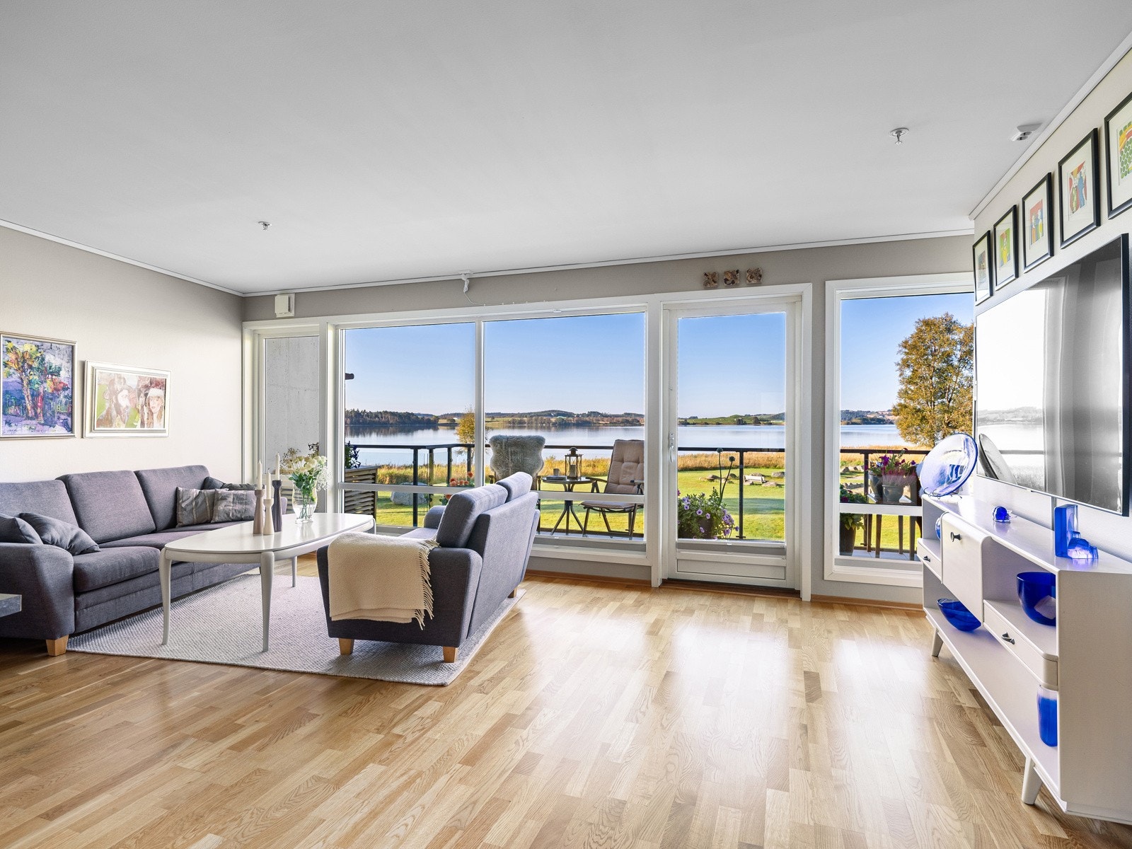 Stuen har 3-stavs parkettgulv og veggflater malt i en lys gråtone. Galleribilde