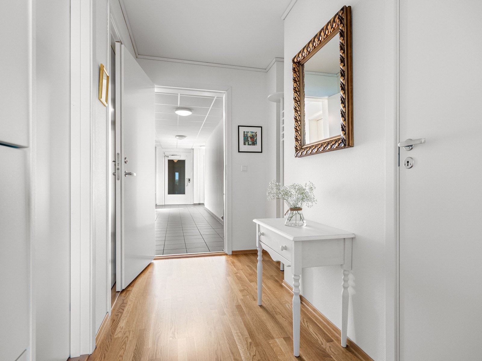 Leiligheten ligger i andre etasje og har adkomst via felles trappeoppgang/heis. Entreen er innbydende med 3-stavs parkettgulv og hvitmalte veggflater. I entreen er det ellers tilrettelagt nisje for garderobeløsning. Galleribilde