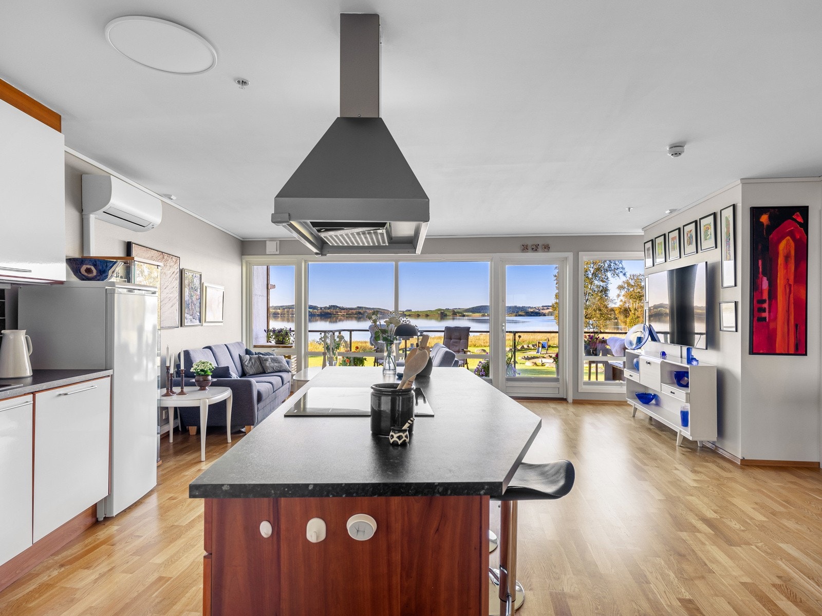 Under overskap er det belysning og sorte fliser, og over kokesonen er det installert en stilig ventilator. Galleribilde