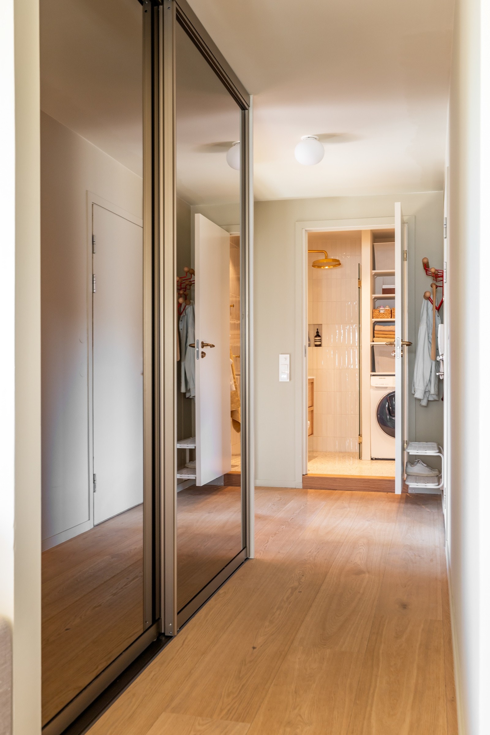 Velkommen inn - Tiltalende og romslig entré som gir et godt førsteinntrykk av leiligheten. Innredet med stor skyvedørsgarderobe fra Norske Rival med bronse-speil og flotte taklamper, Glo-Ball, fra Flos. Galleribilde