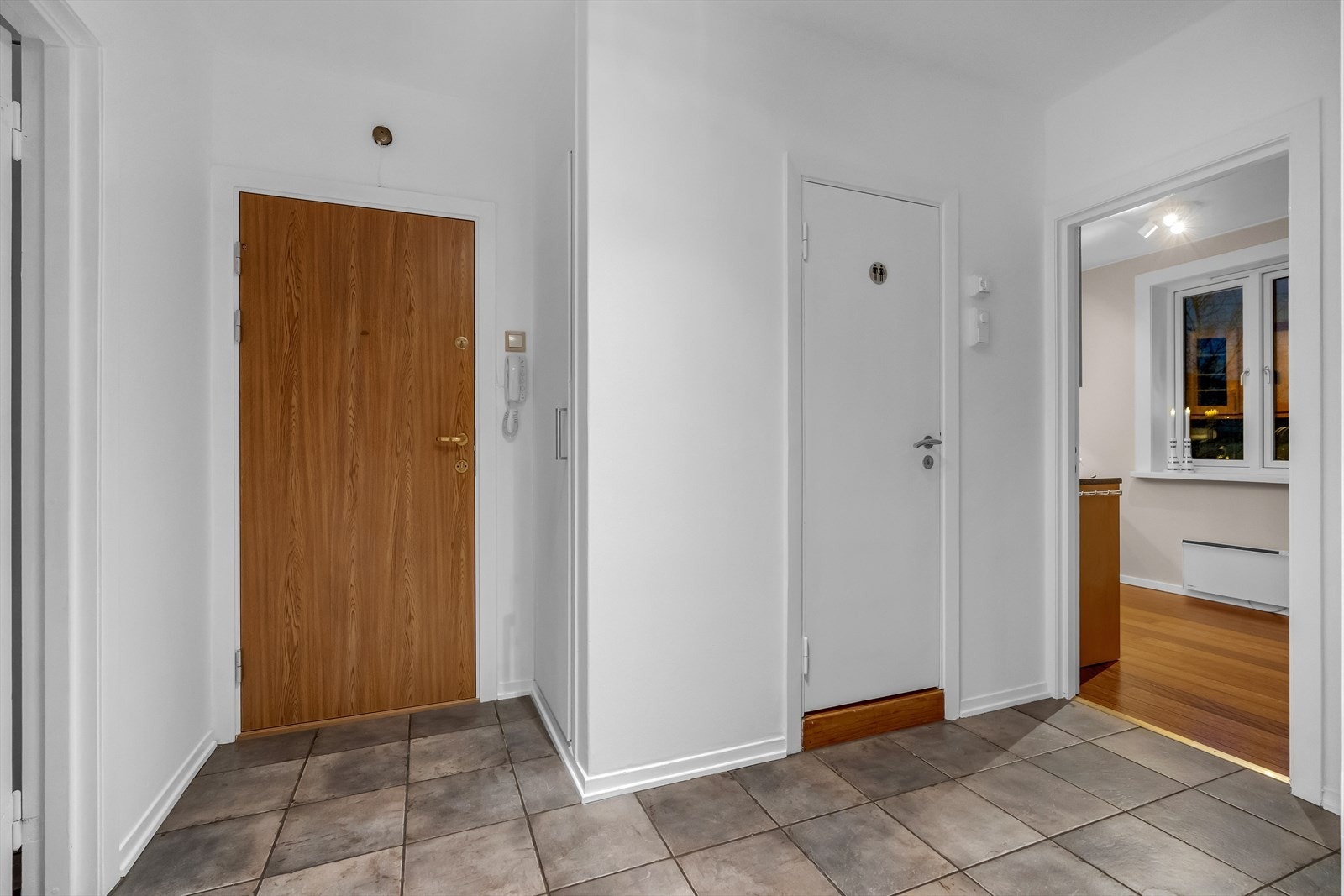 Leiligheten har en lys og romslig entré med fliser på gulvet. Galleribilde