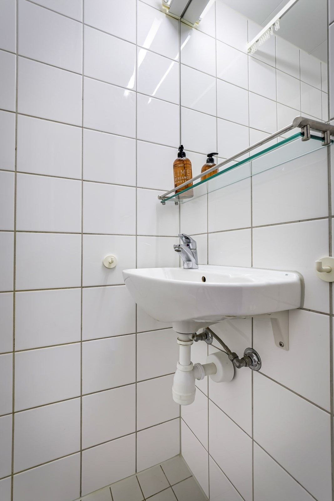 Pent og funksjonelt flislagt bad, renovert i regi av borettslaget. Utstyrt med vegghengt speil, klosett, servant og praktisk oppbevaring i skap Galleribilde