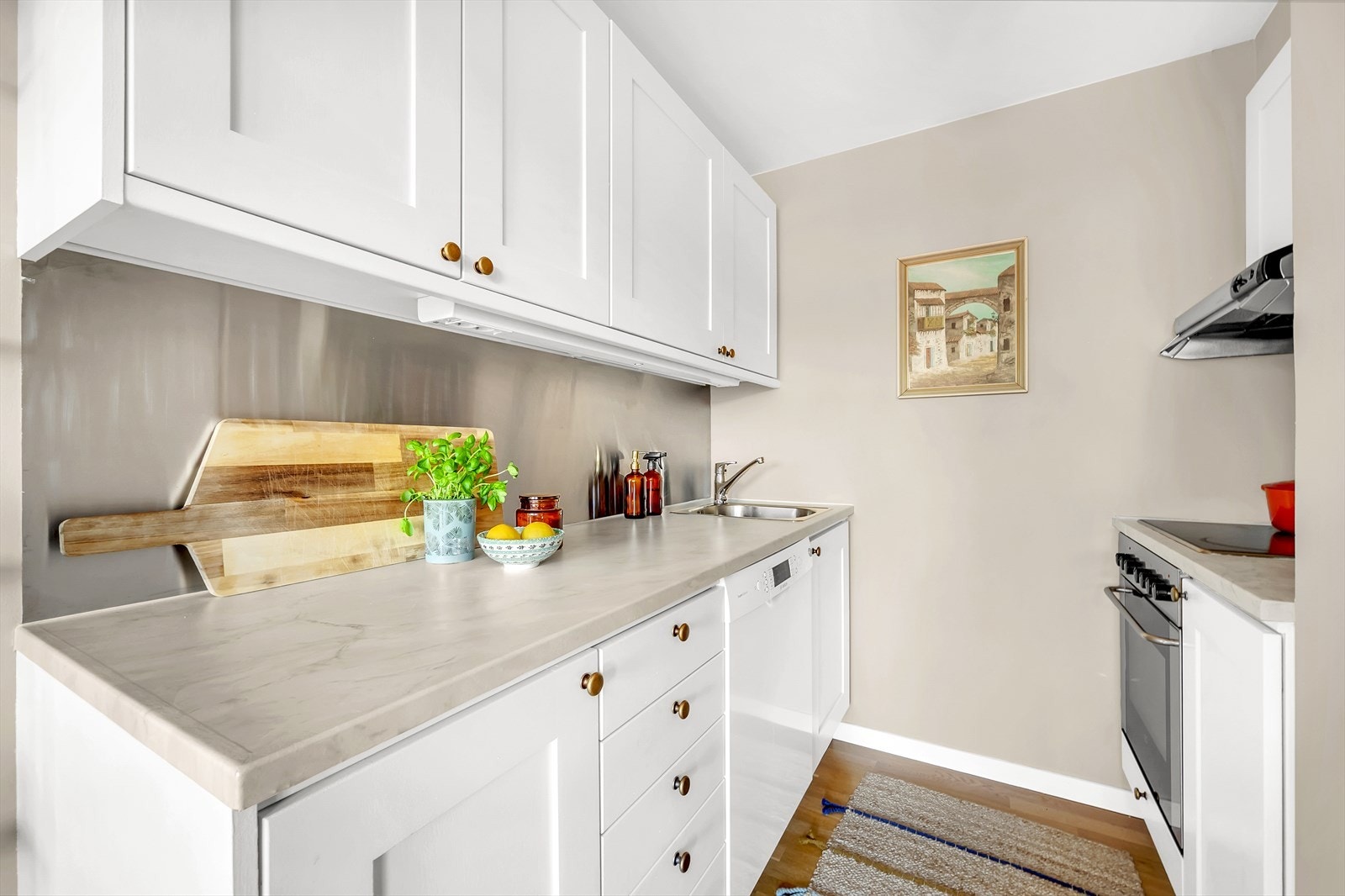 Kjøkkeninnredning har profilerte fronter, laminat benkeplate med nedfelt vaskekum, samt integrert platetopp, stekeovn og oppvaskmaskin. Galleribilde