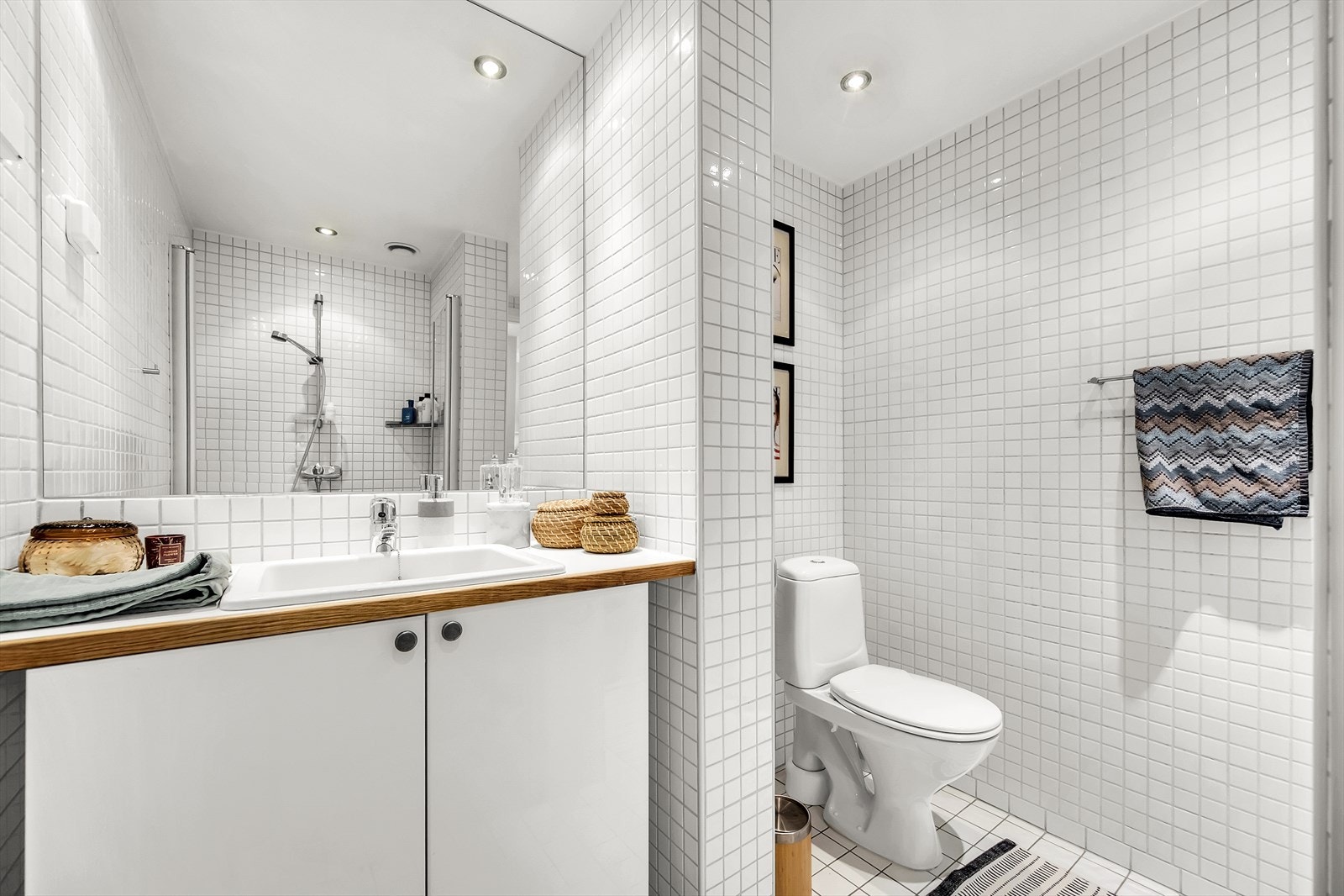 Praktisk og arealeffektivt baderom innredet med klosett, servant nedfelt i innredning, samt innfelt speil. Galleribilde