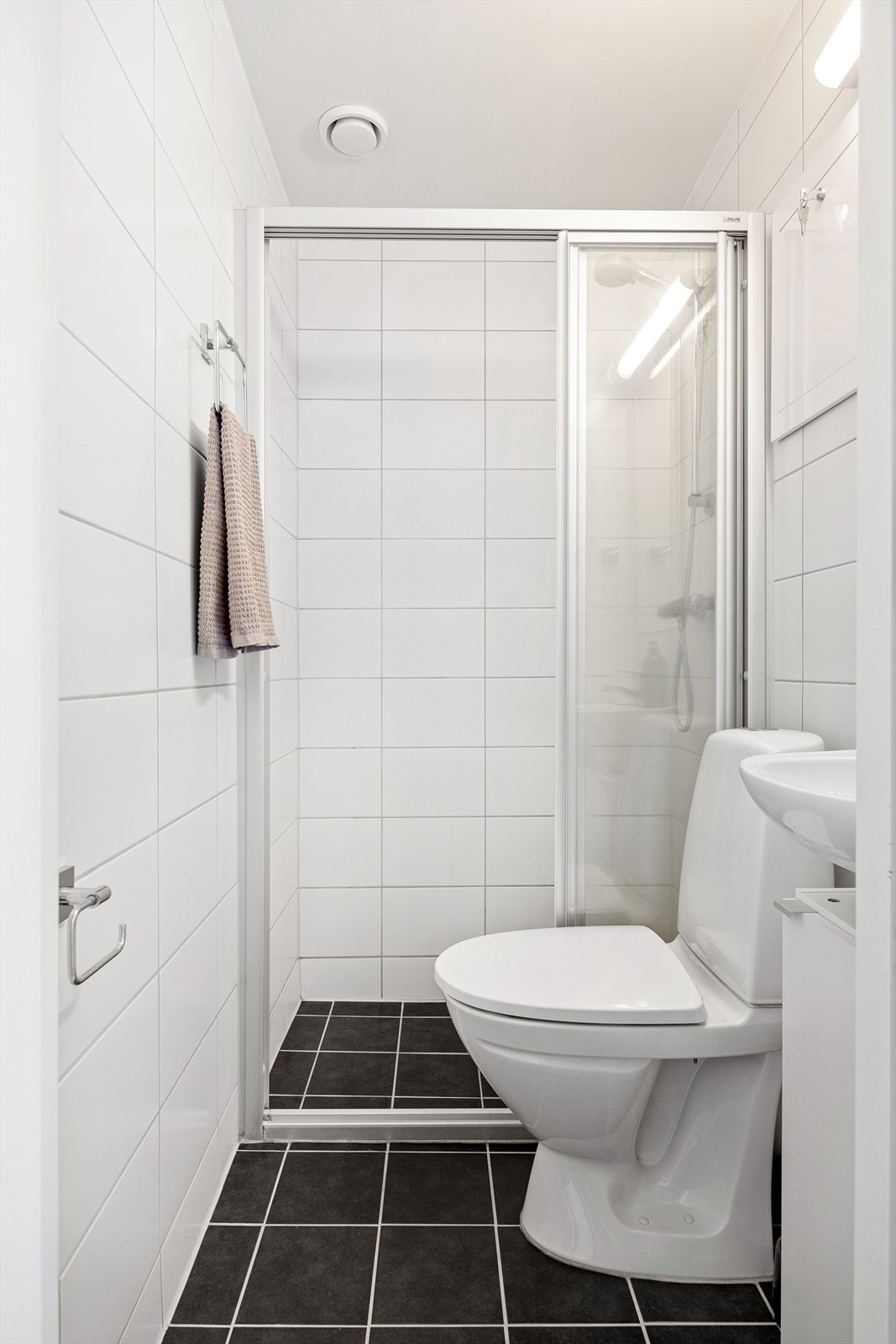 Delikat flislagt baderom fra 2014 med varmekabler i gulv. Badet består av wc, dusjplass med vegger og servant med ettgreps blandebatteri. Galleribilde