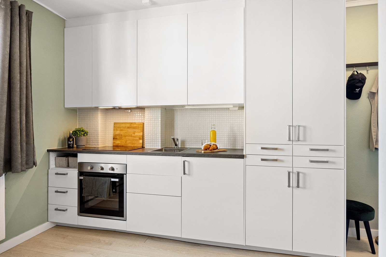 Her har du en tidsriktig kjøkkeninnredning med hvitevarer som komfyr med induksjonstopp og kjøleskap med fryser. Integrert garderobeskap med oppbevaringsplass for klær. Galleribilde