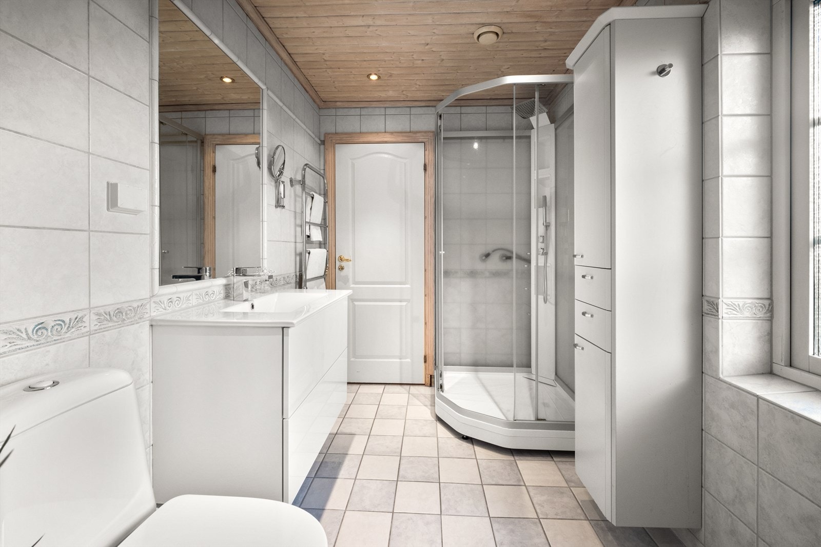 Videre har badet toalett, innredning med servant, skap og dusjkabinett. Galleribilde