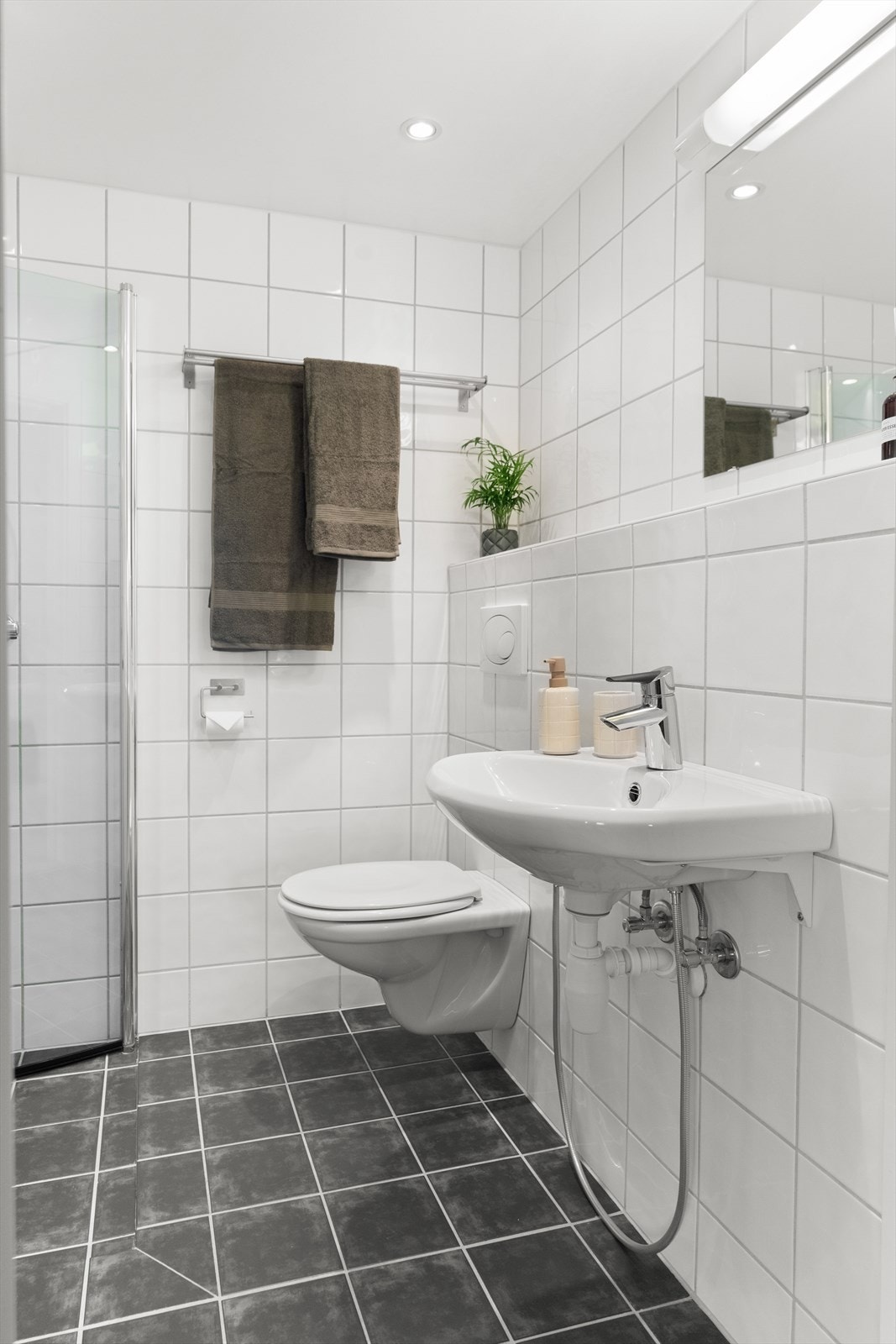 Innredningen består av et overskap, servant, speil og armatur med stikk og en dusjsone. Galleribilde