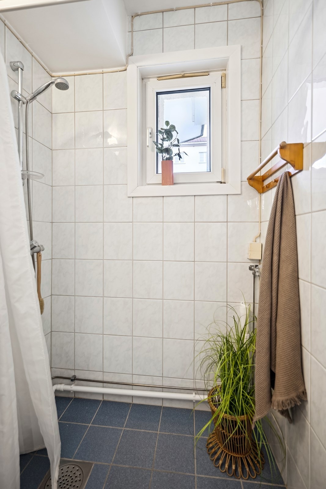 Rommet er innredet med servant, speilskap, klosett, dusj direkte på gulv med termostat batteri og plass for vaskemaskin. Galleribilde