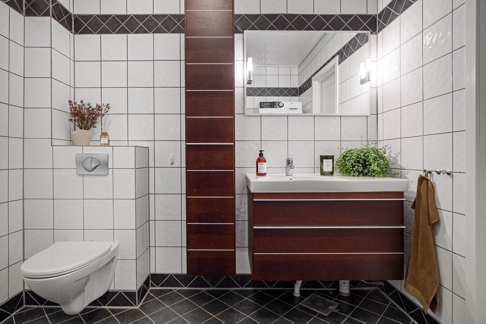 Inneholder heldekkende servant med skuffer, speil med belysning, veggmontert høyskap, dusjhjørne med innfellbare dører i herdet glass, vegghengt klosett og opplegg for vaskemaskin/tørketrommel. Galleribilde