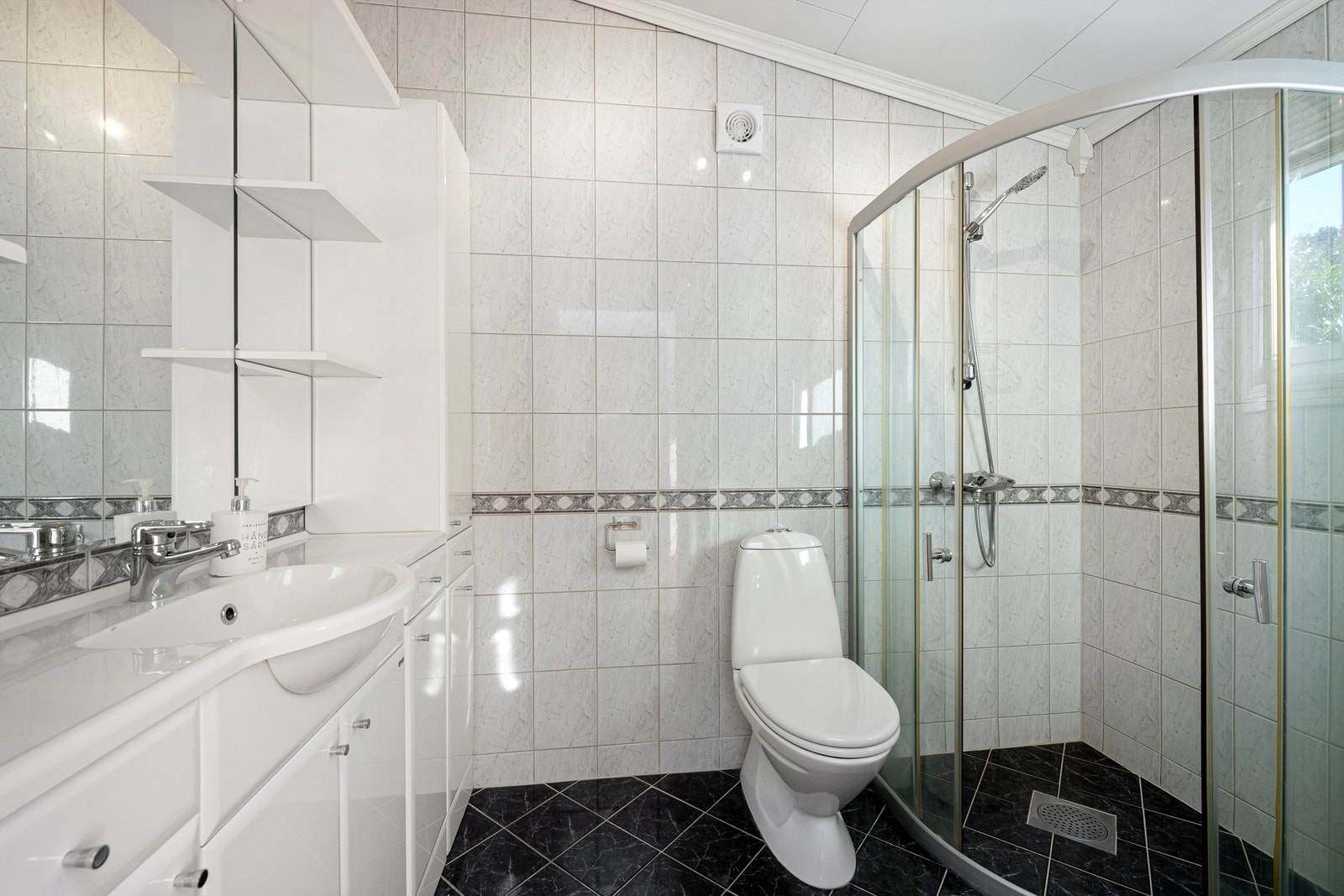 Badet ble oppgradert i 2012 og har flislagt gulv med gulvvarme og flislagte vegger. Dusjhjørne ved glassvegger og vegghengt dusjarmatur. Gulvstående toalett. Galleribilde