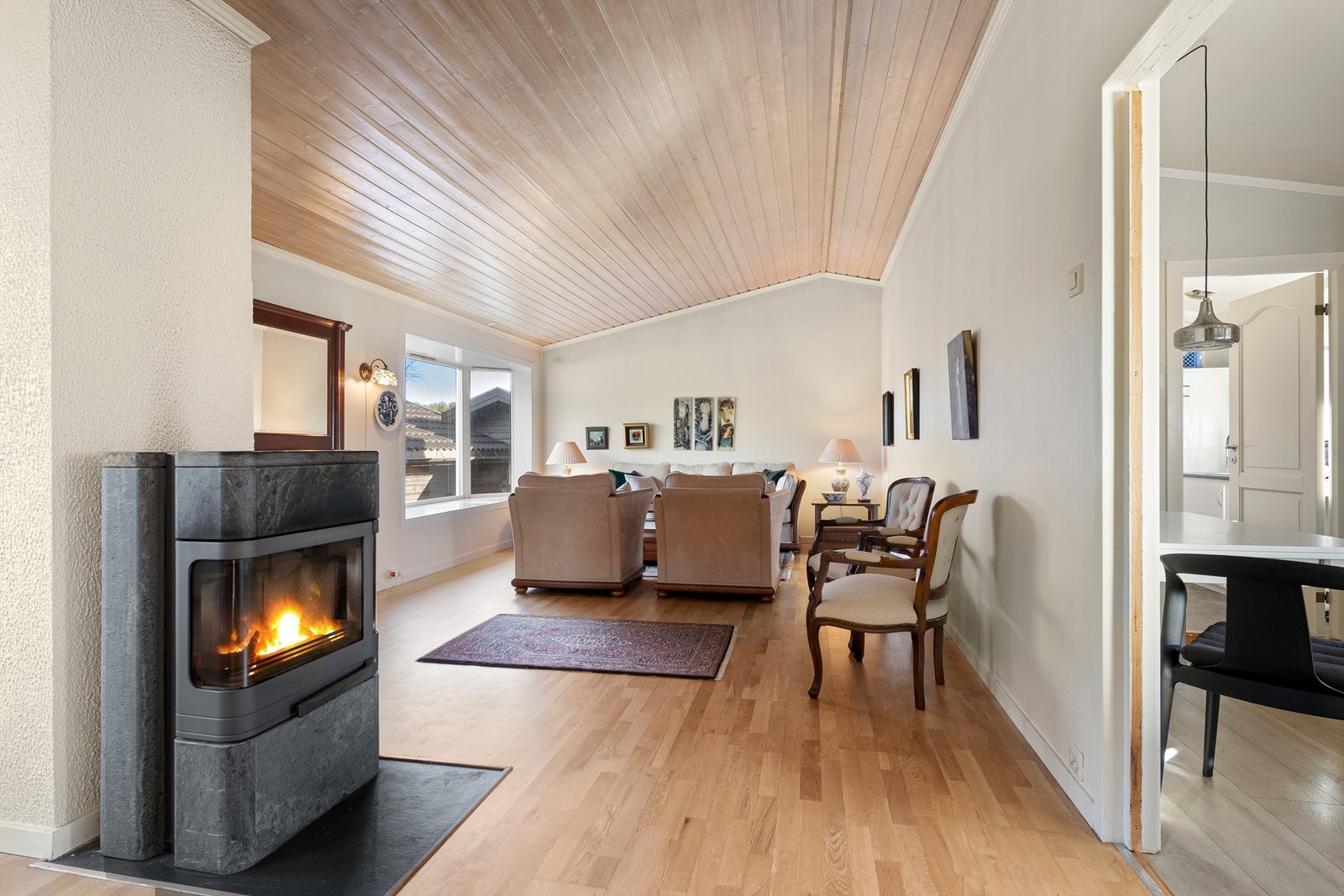 Nyere klebersteinspeis i stue med glassdør som gir en lun og hyggelig atmosfære. Galleribilde