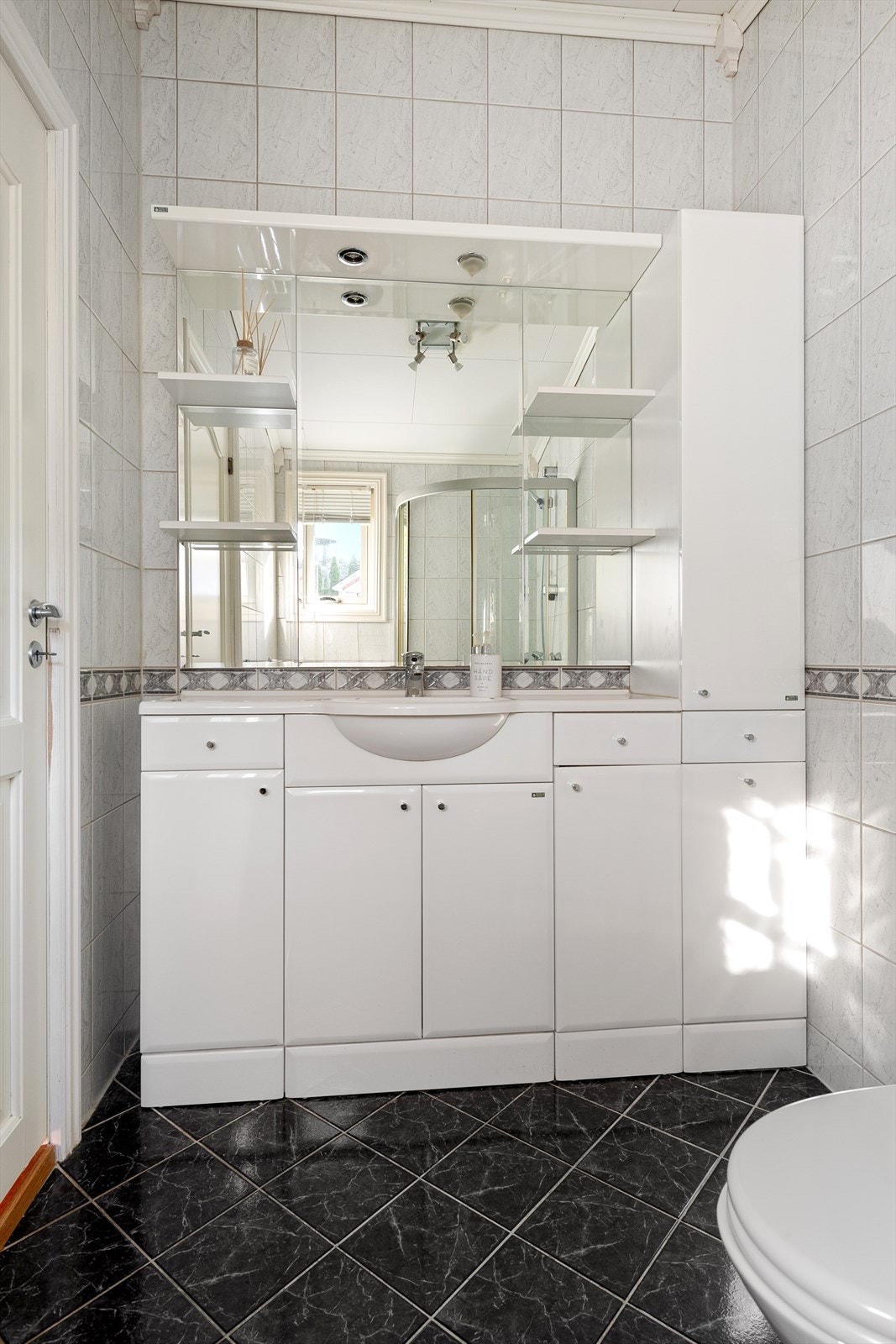 Stor og romslig innredning med god skapplass. Ovenpåliggende servant med armatur. Speil med overlys og stikkontakt i sideskap. Galleribilde