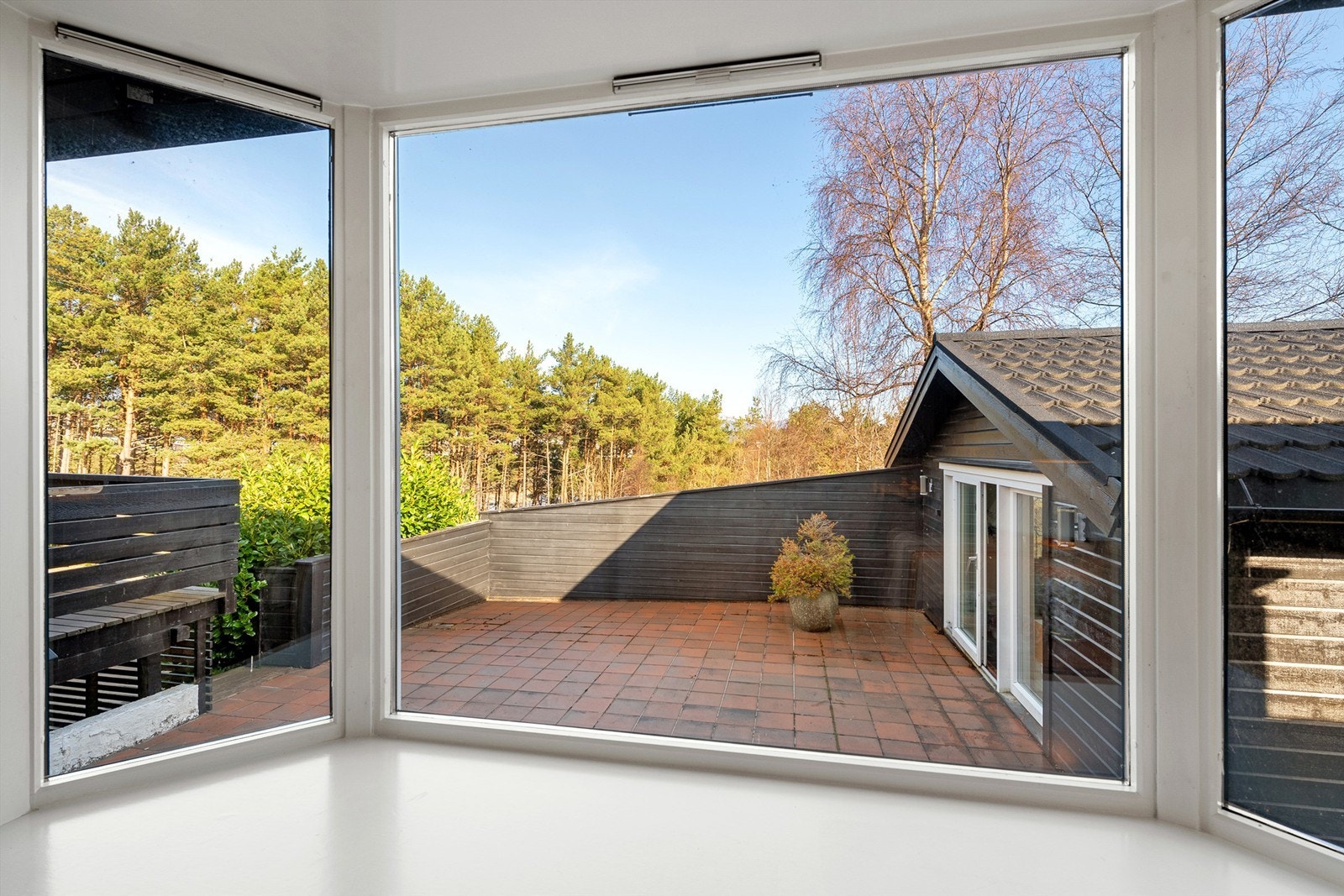 Utsikt fra karnappvindu på stue til markterrasse og utestue mot nordvest Galleribilde